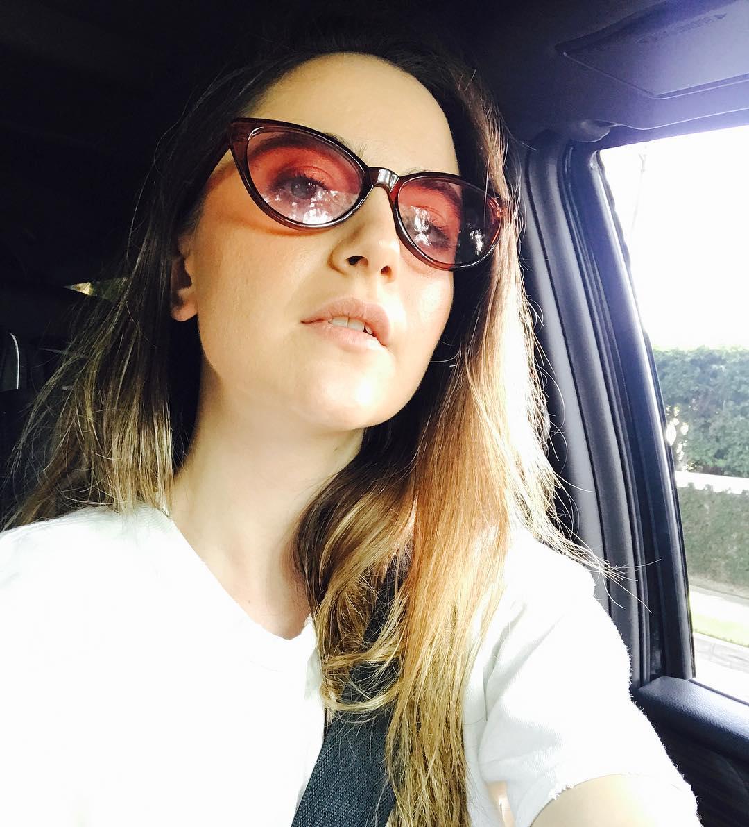 Alexa Nikolas taking a selfie in a car with sunglasses on