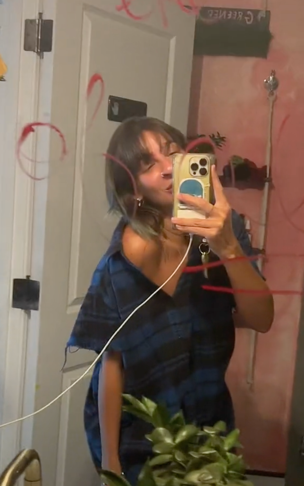 Gabbi hanna taking a selfie in the mirror with red words written on it