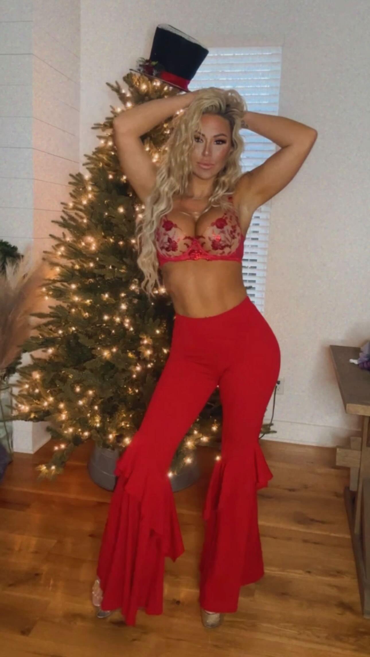 Kindly Myers dances in front of the Christmas tree in red pants and lingerie