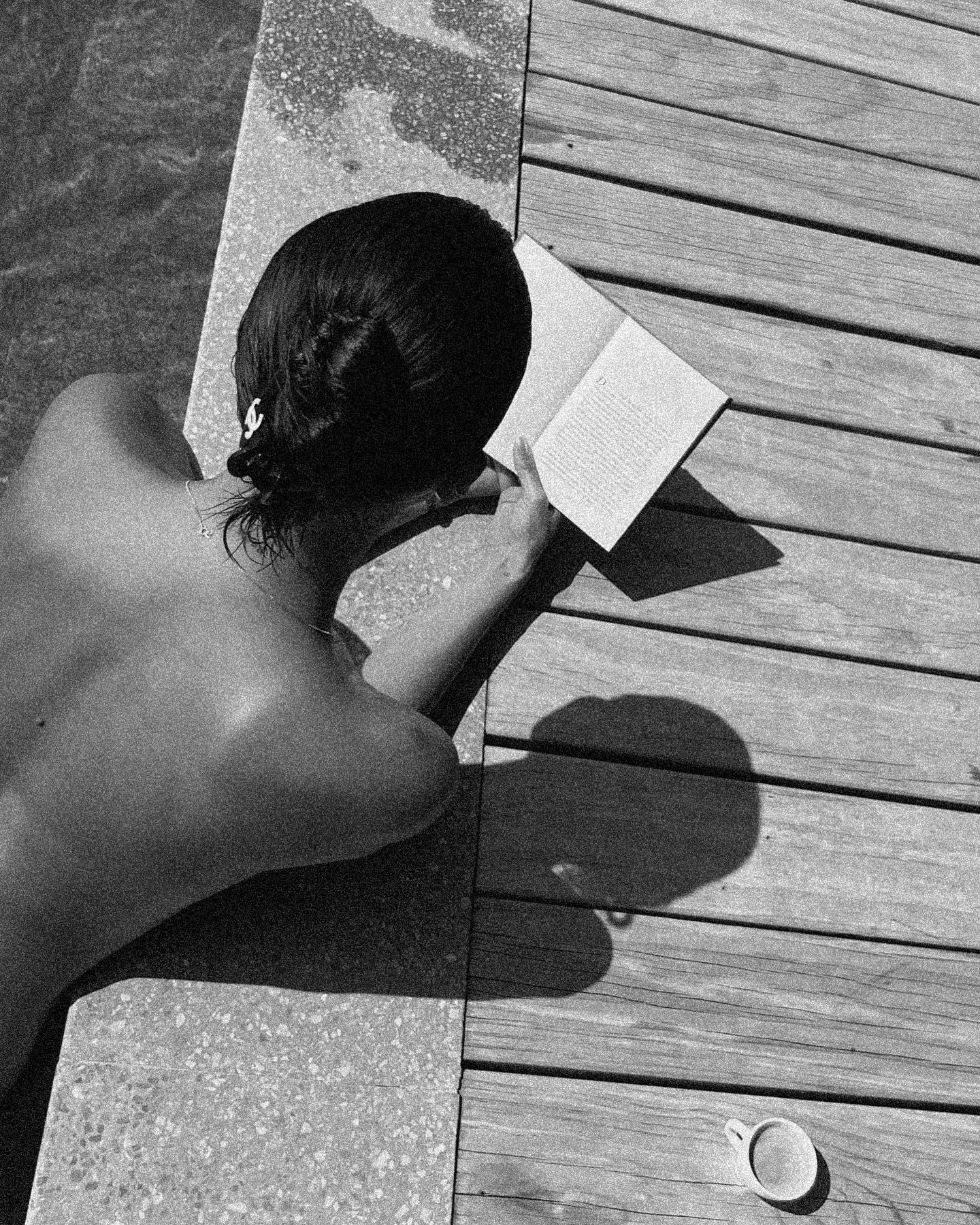 Nicole Poturalski reads a book topless