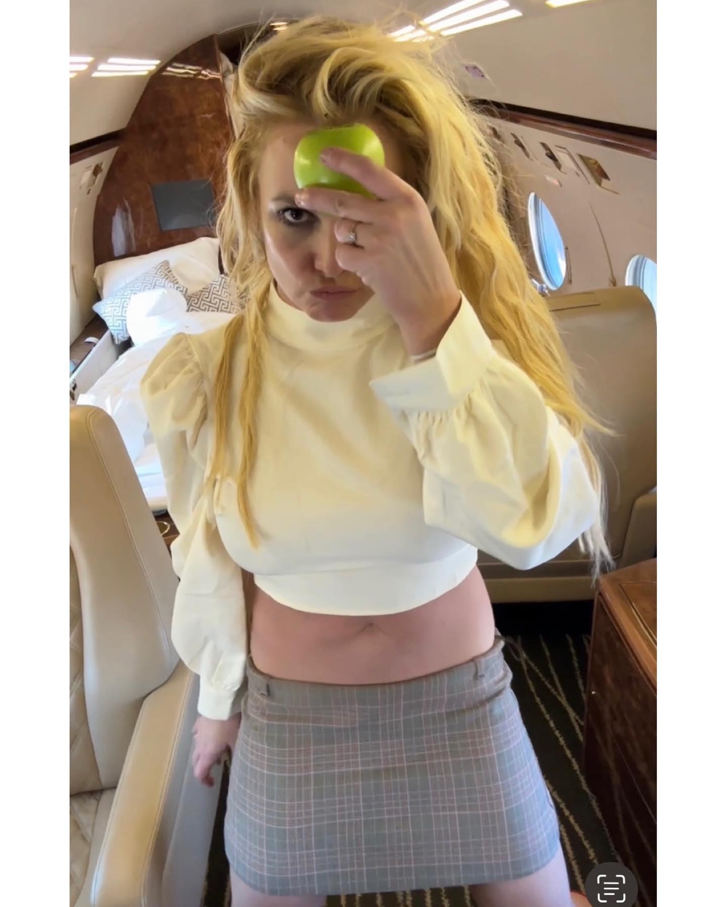 Britney Spears shows herself holding an apple on a plane