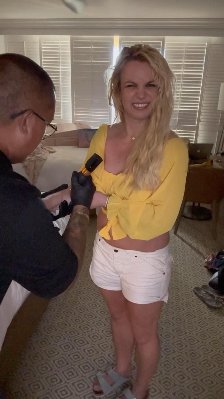 Britney Spears gets a tattoo at a hotel room in Maui
