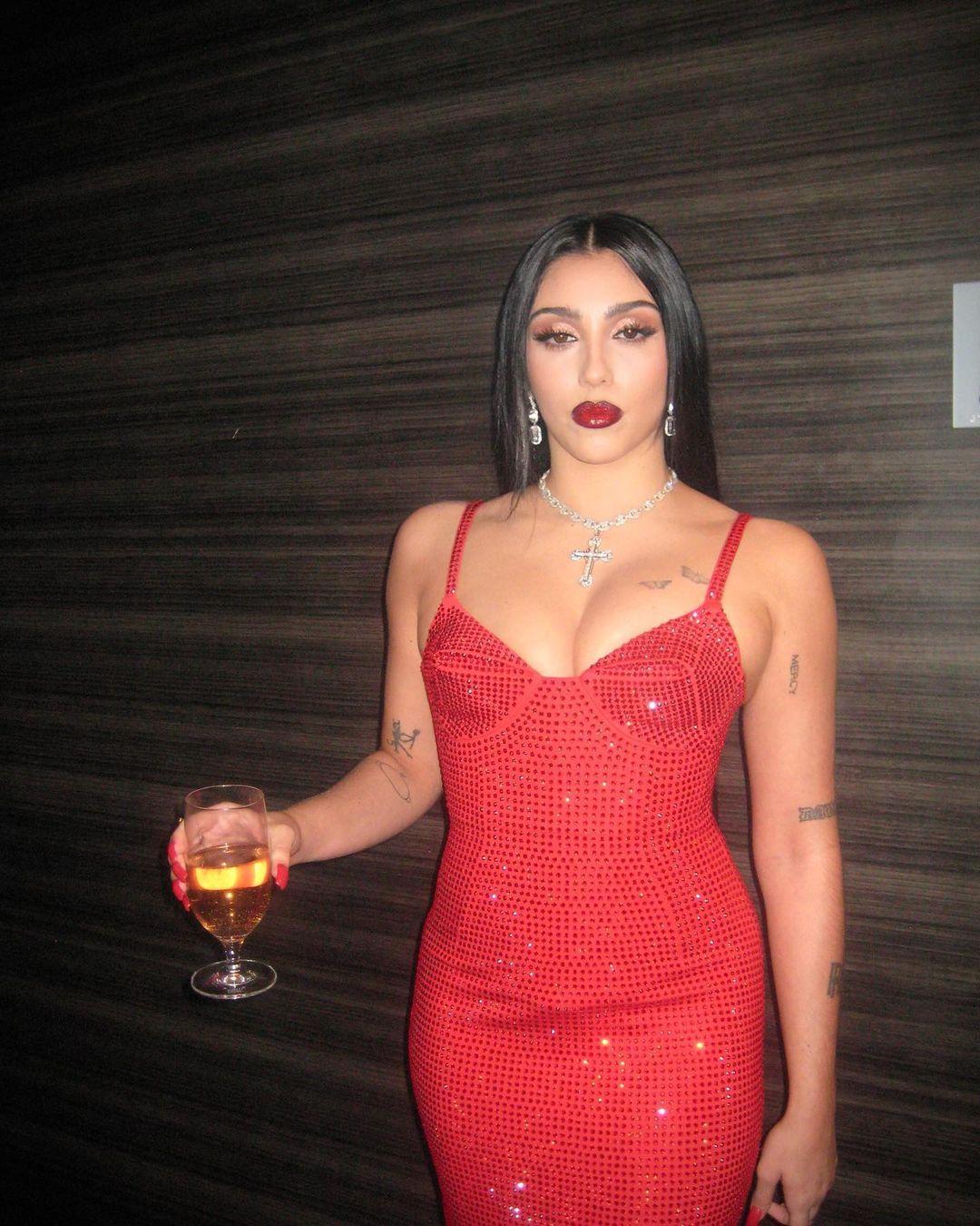 Lourdes Leon posing for the camera in a red dress.
