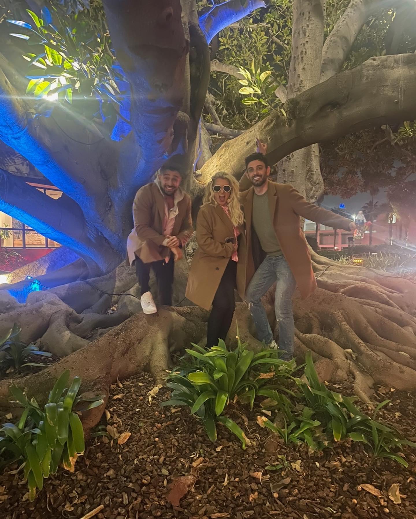 Britney Spears poses with friends in front of a large white tree