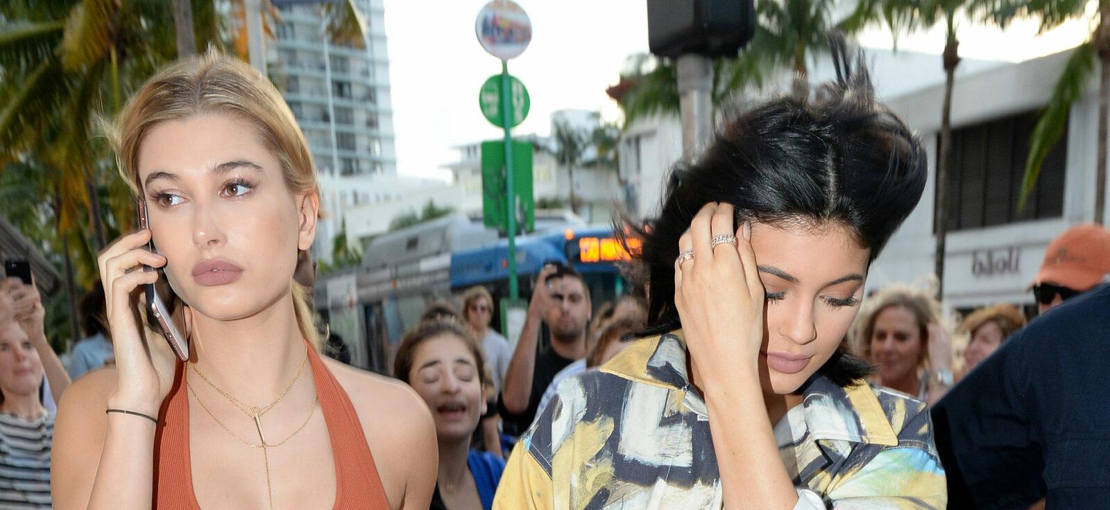 Kylie Jenner wearing an art-patterned jumpsuit shops with model friend Hailey Baldwin in South Beach