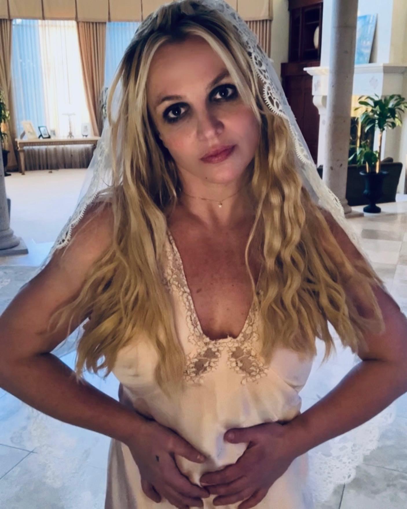 Britney Spears in nightgown holding her stomach
