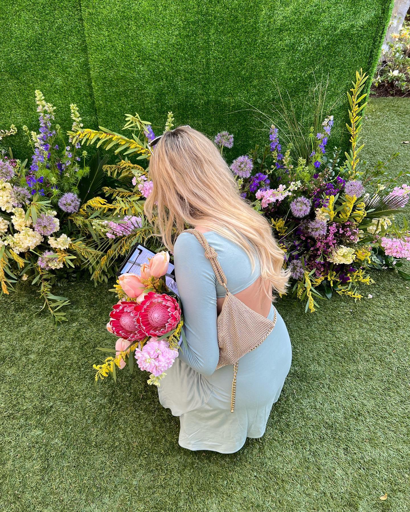 Carly Lawrence picks flowers in a green dress