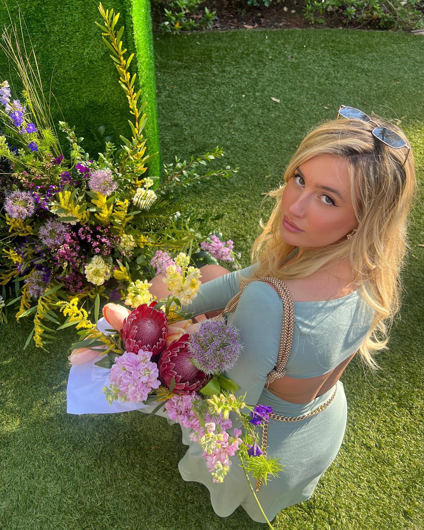 Carly Lawrence picks flowers in a green dress 
