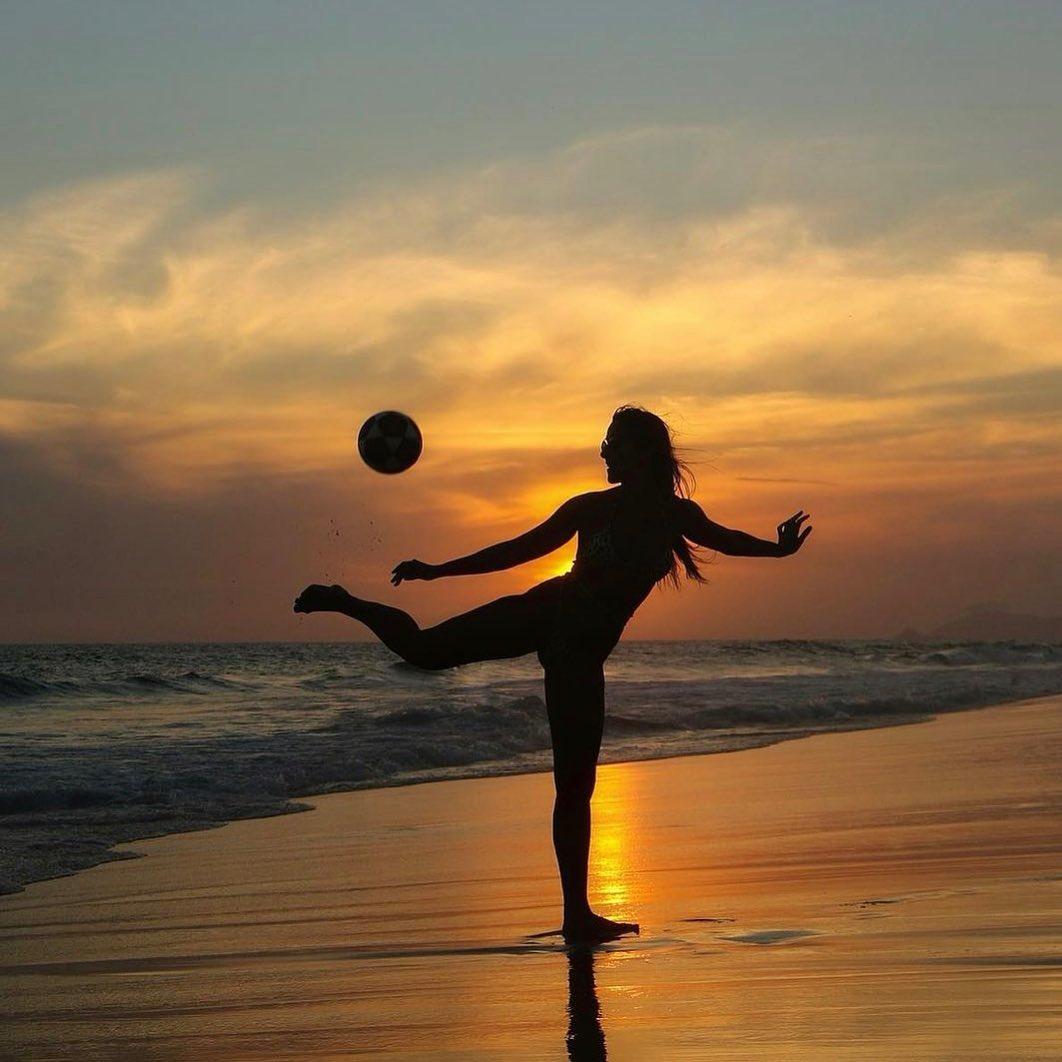 Natalia Guitler takes a photo on the beach with a ball