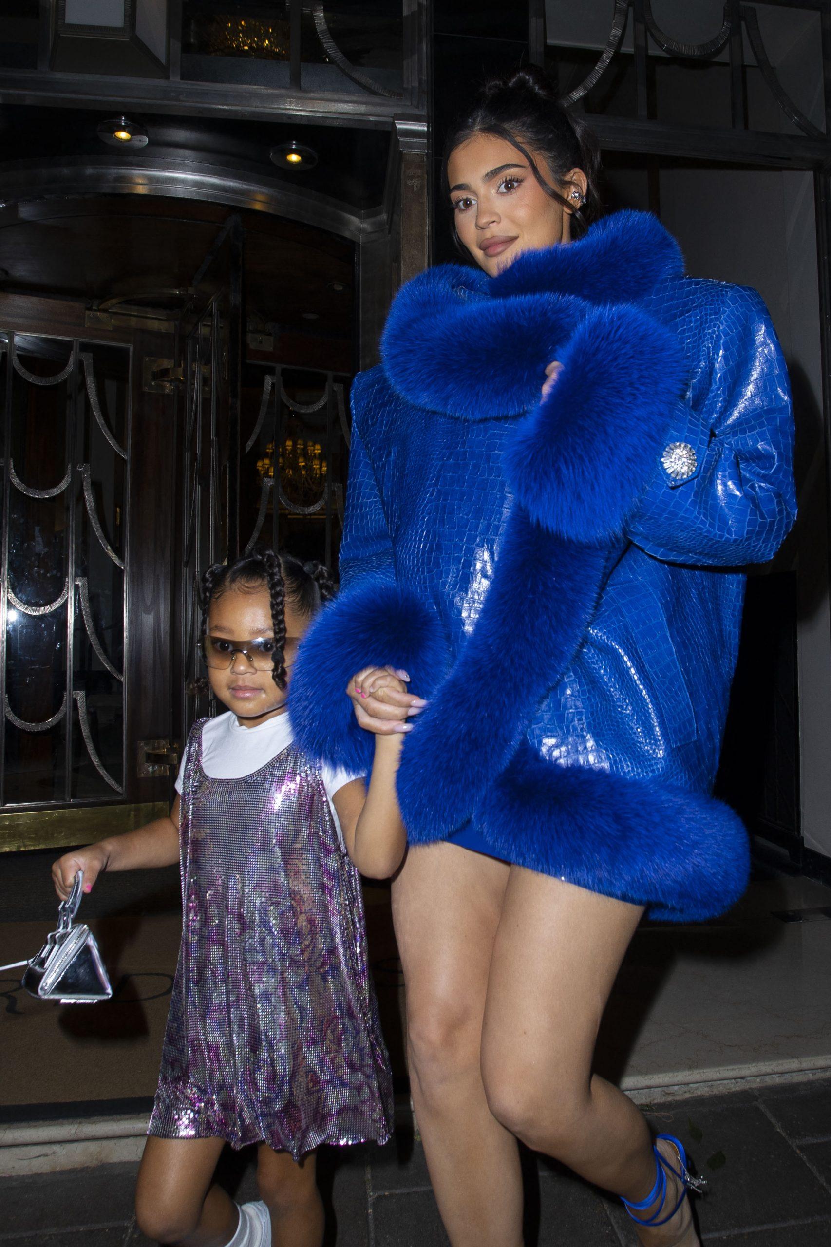 Kylie Jenner and daughter Stormi wow fans as they leave their hotel wearing an oversized blue crocodile skin and fur coat, with a very leggy display
