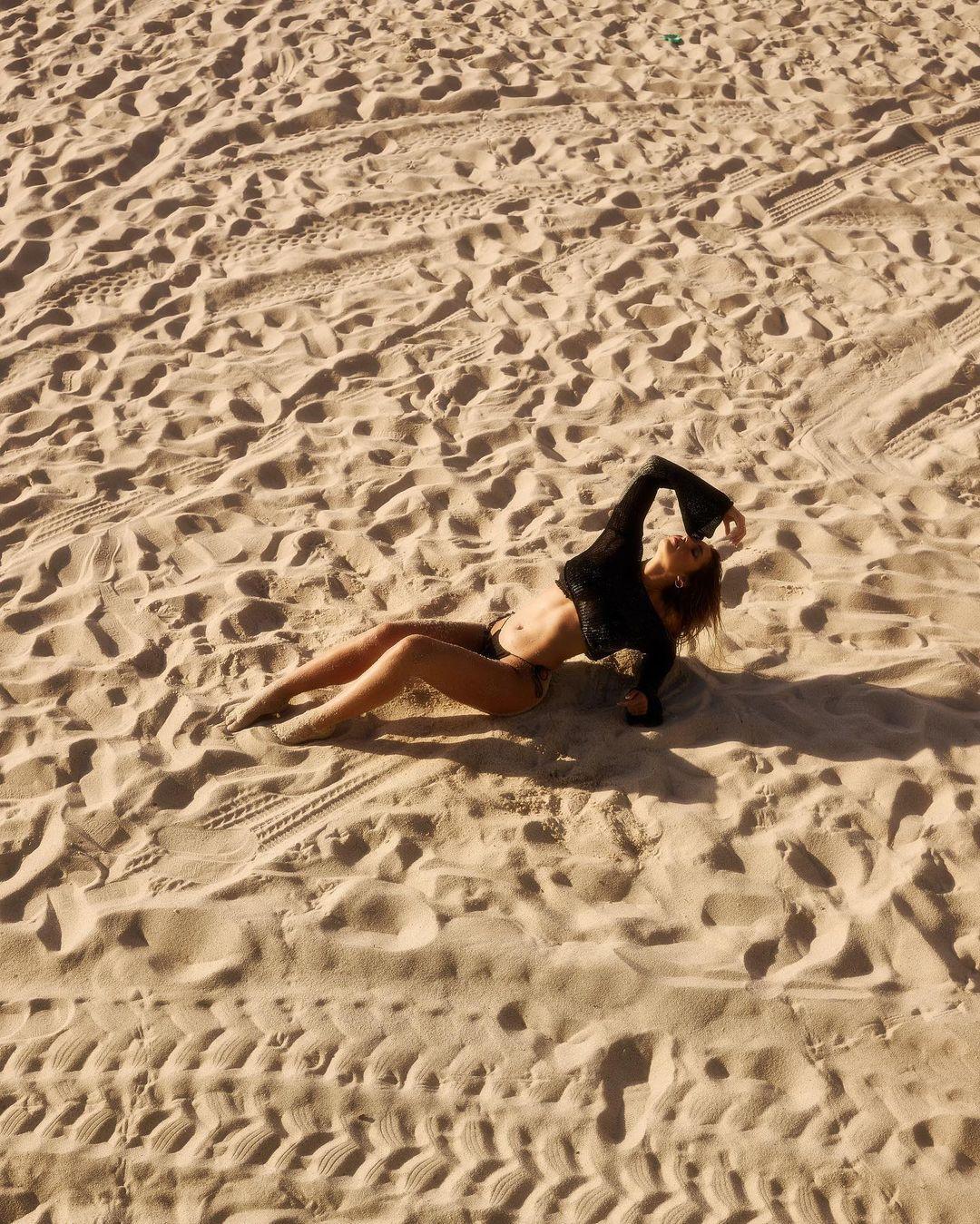 Andreea Dragoi lounging on the sand.