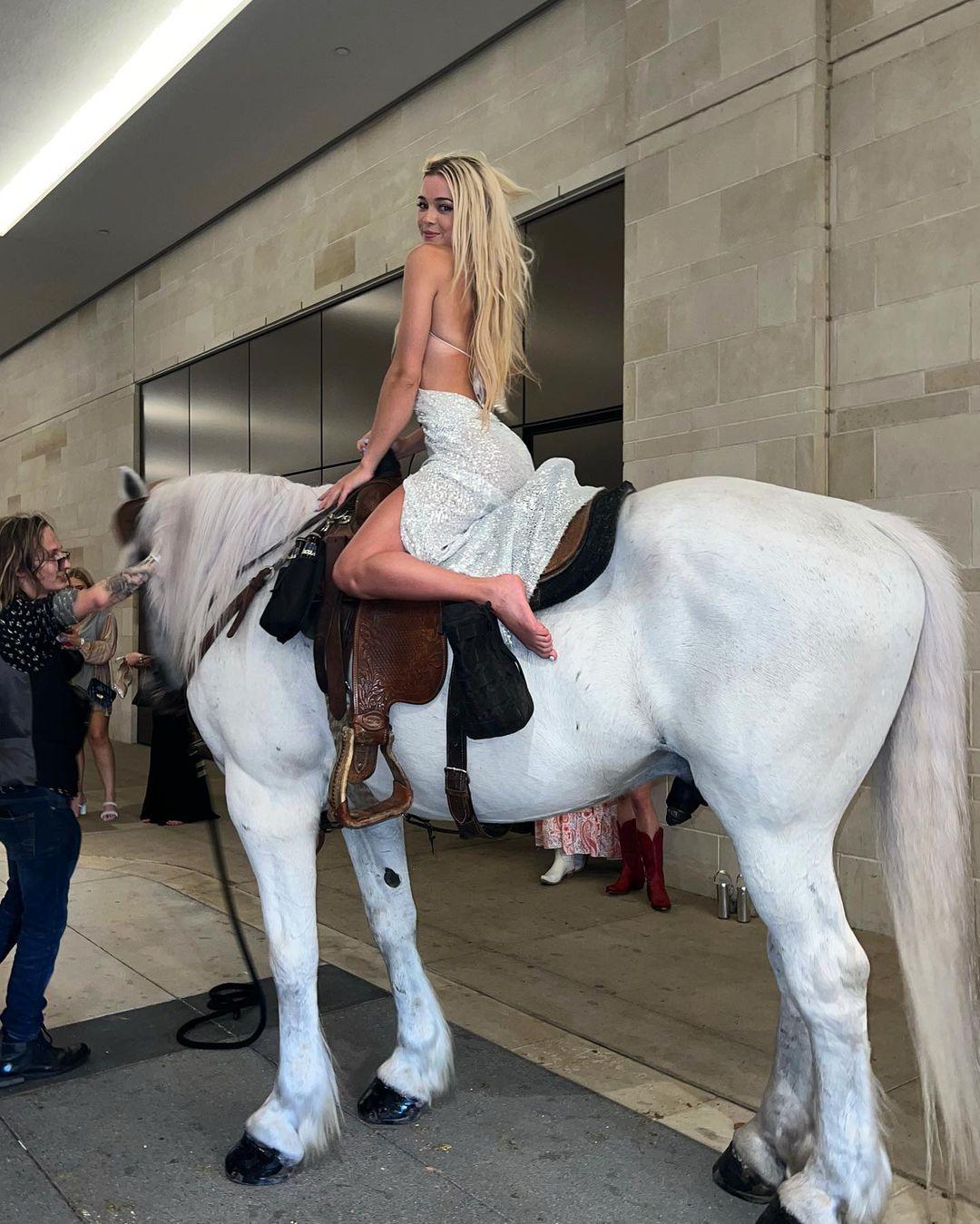 Olivia Dunne riding a white horse.