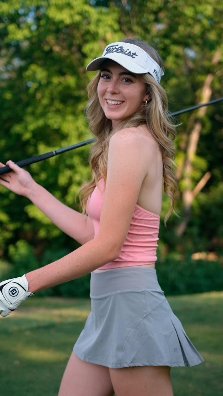 Grace Charis golfs in a pink crop top