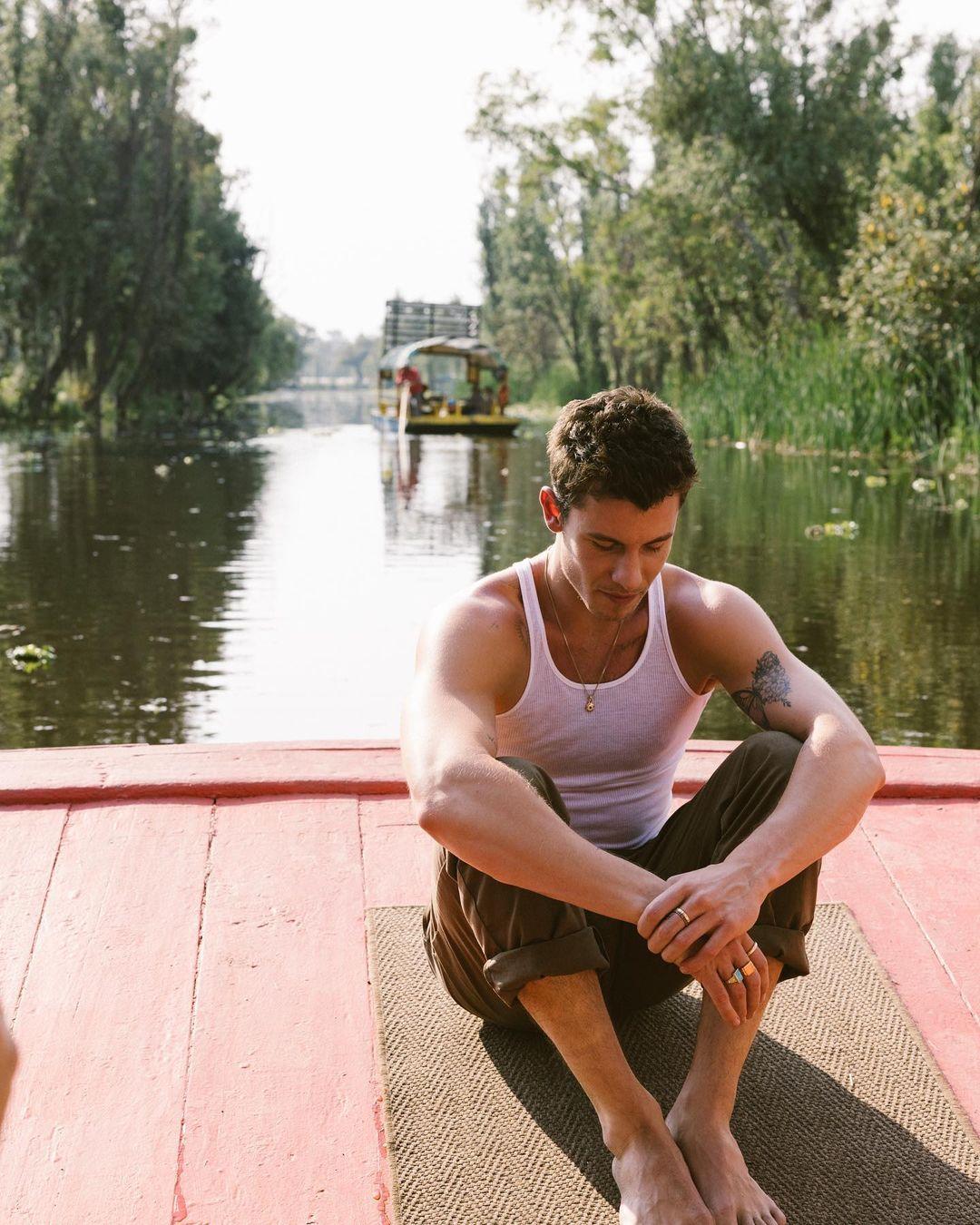 Portrait of Shawn Mendes sitting by himself on a river boat