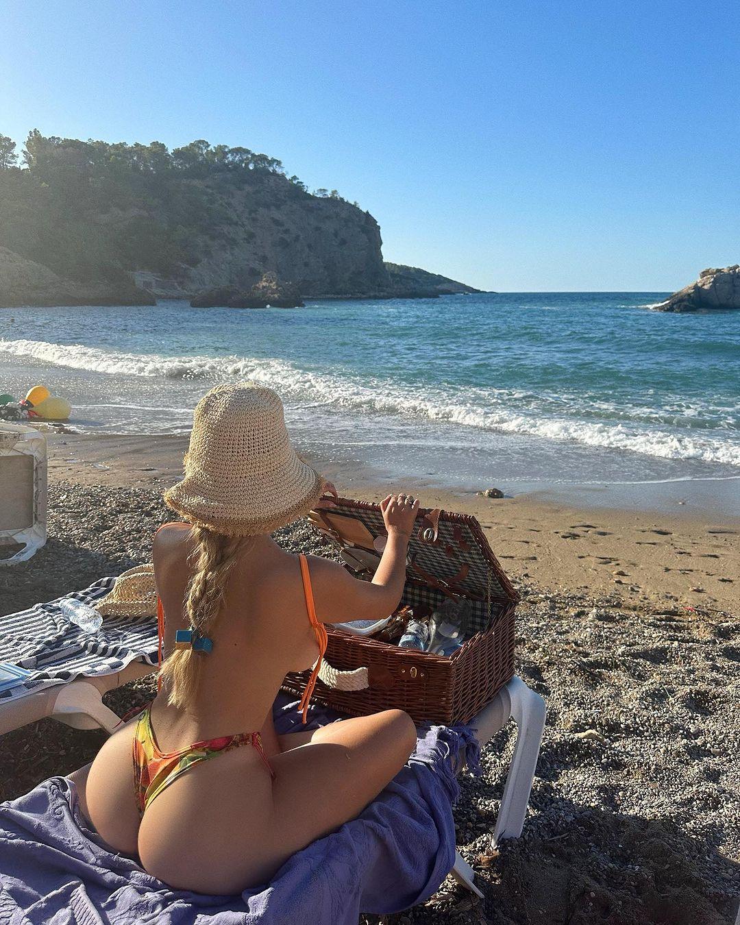 Demi Rose enjoys a picnic at the beach in her bikini.