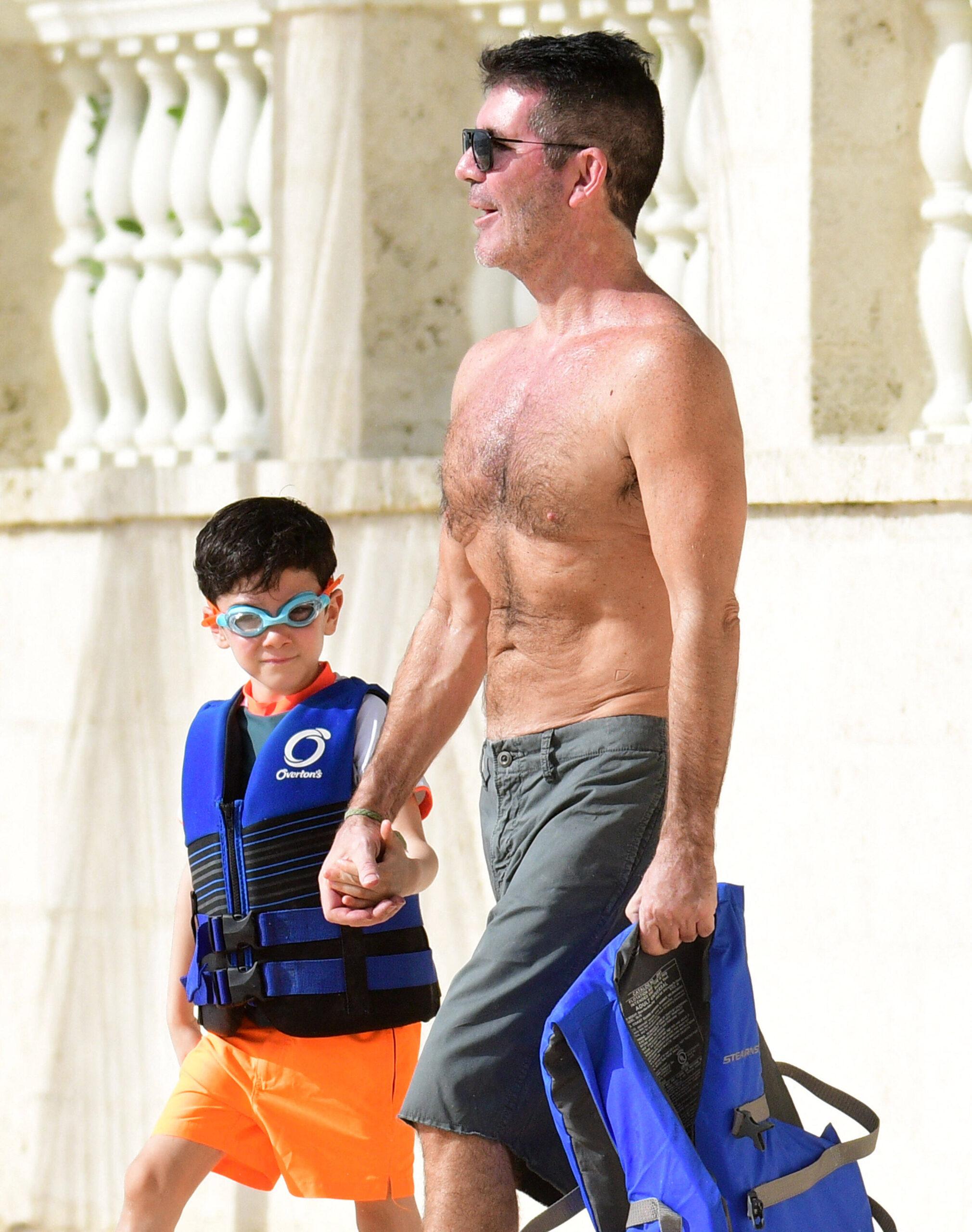Simon Cowell and son Eric pictured on the beach in Barbados