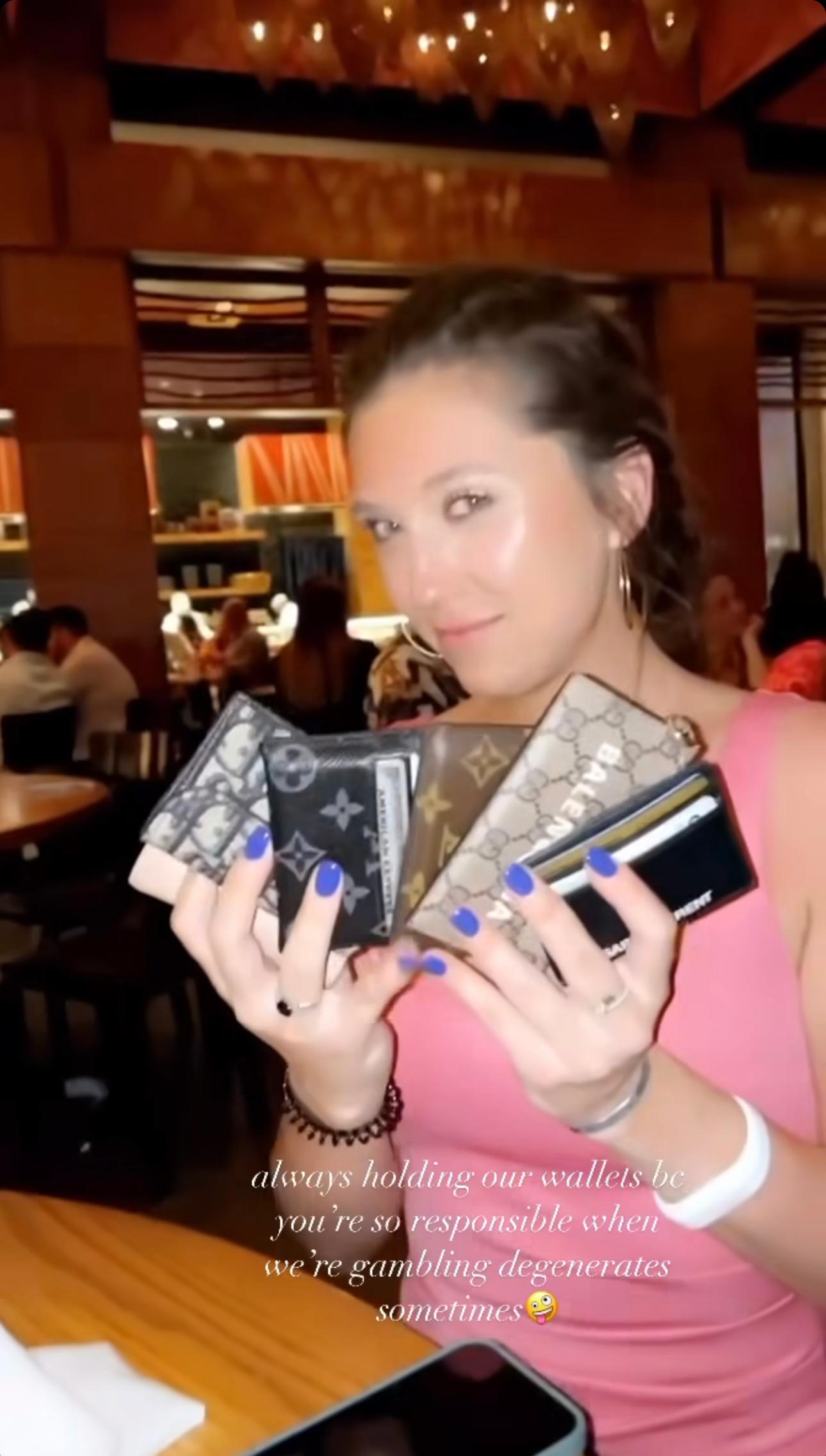 Brielle Biermann's friend Dani Majkowski holding several wallets.