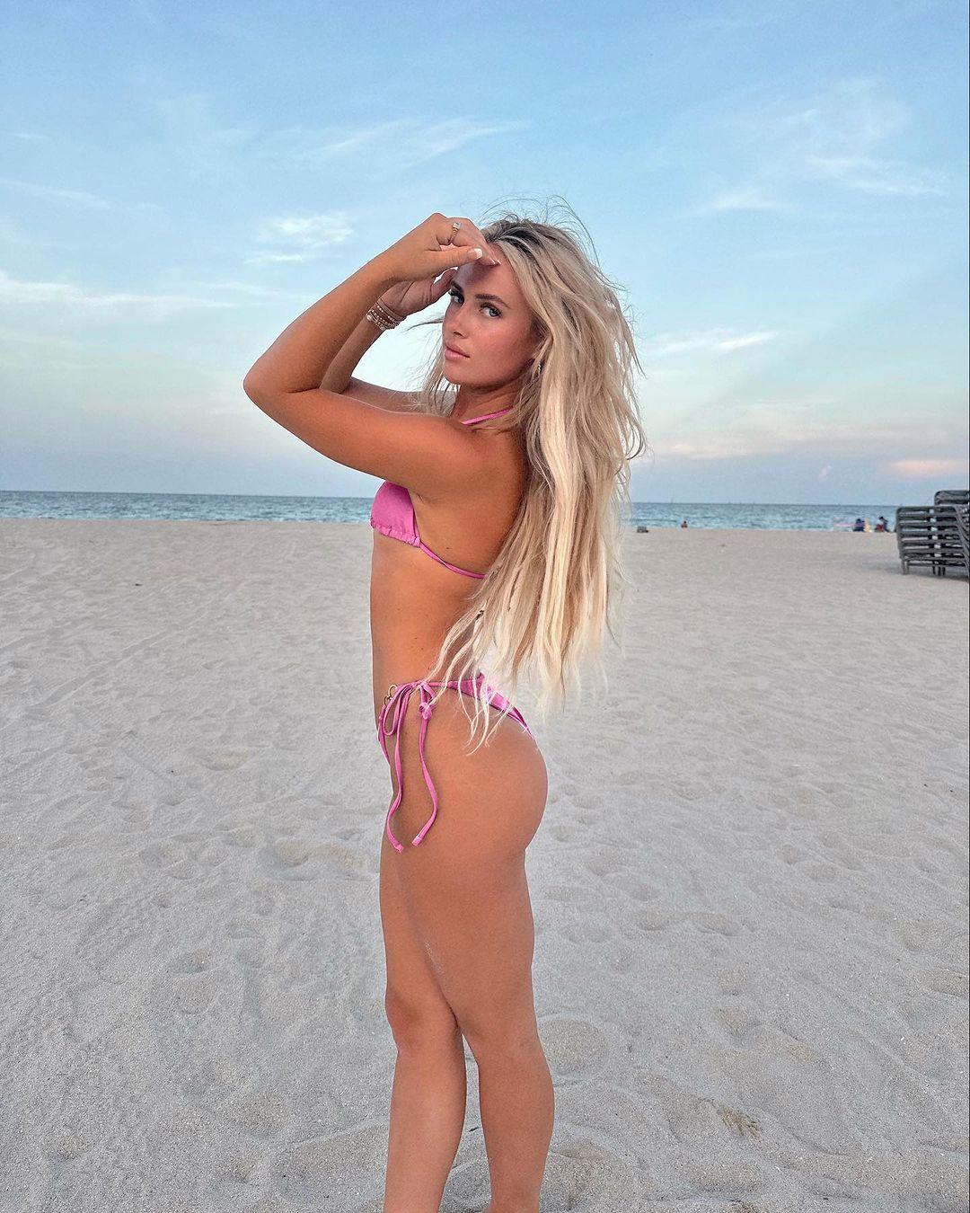 Brylie St. Clair strikes a pose at the beach in her pink bikini.