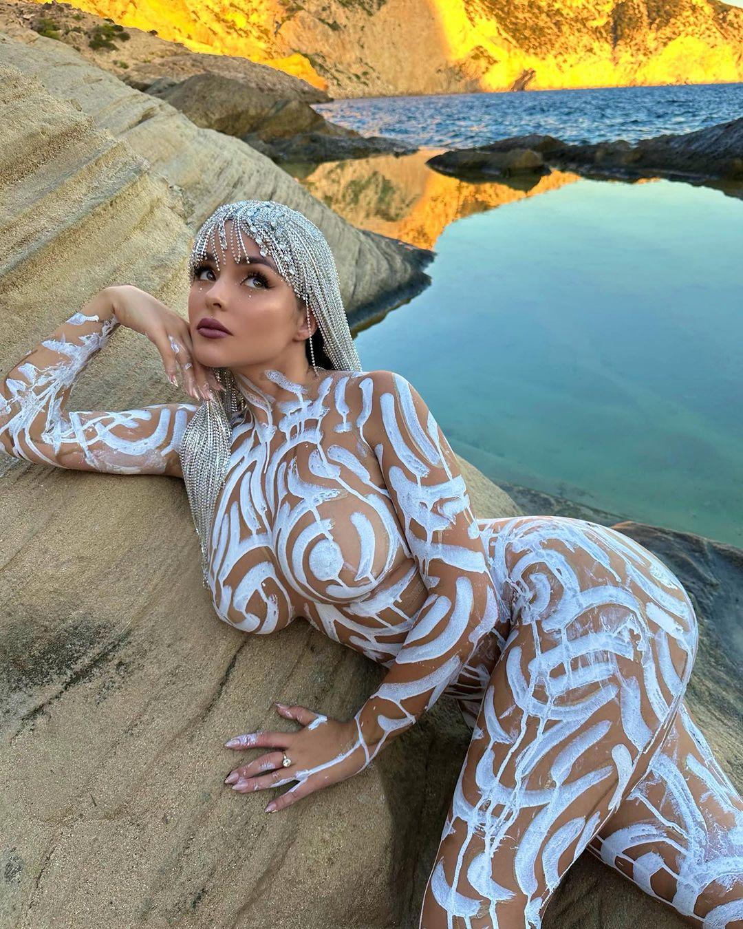 Demi Rose poses for the camera in nothing but white body paint.
