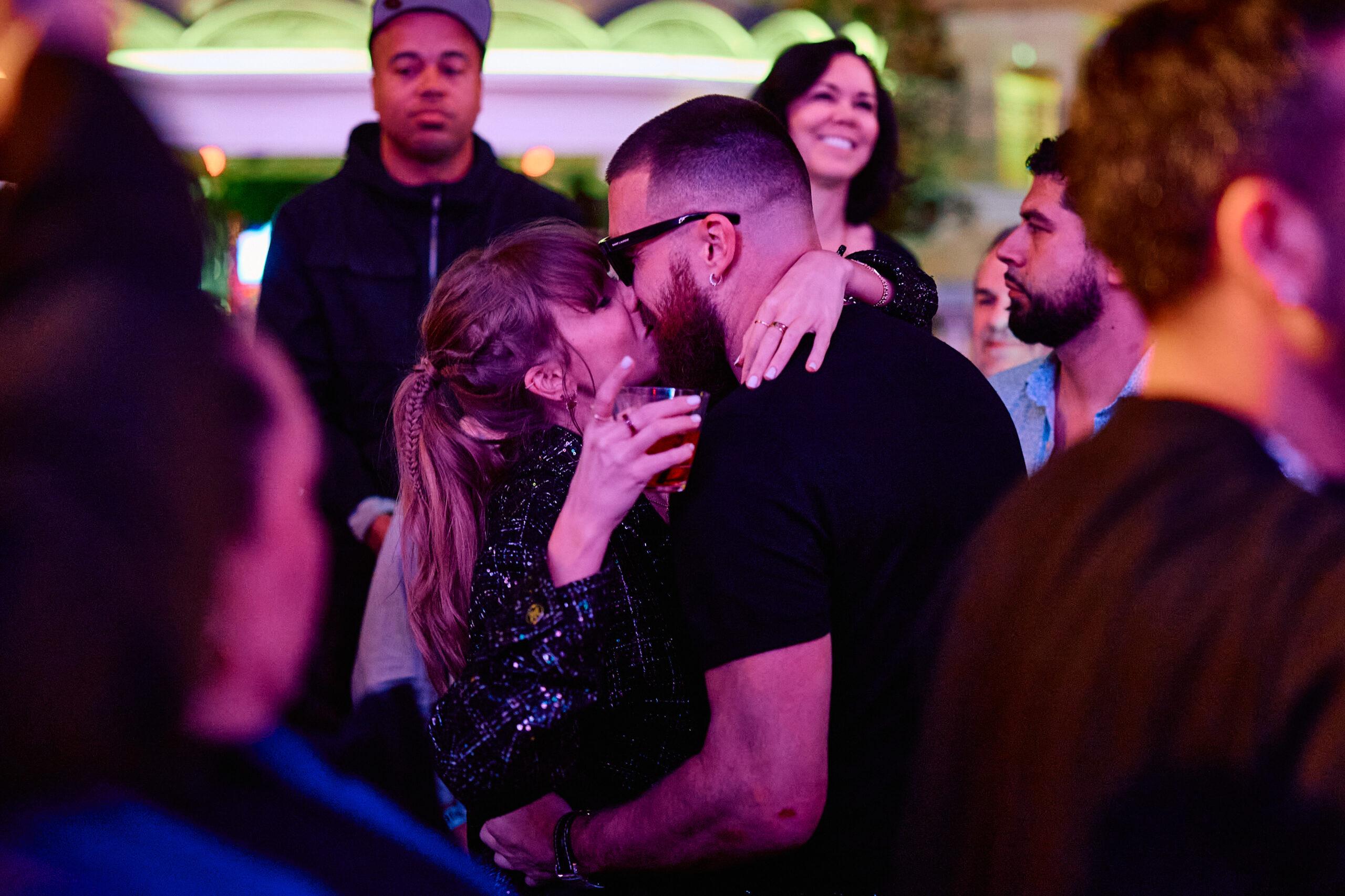 Travis Kelce e Taylor Swift se beijando em festa