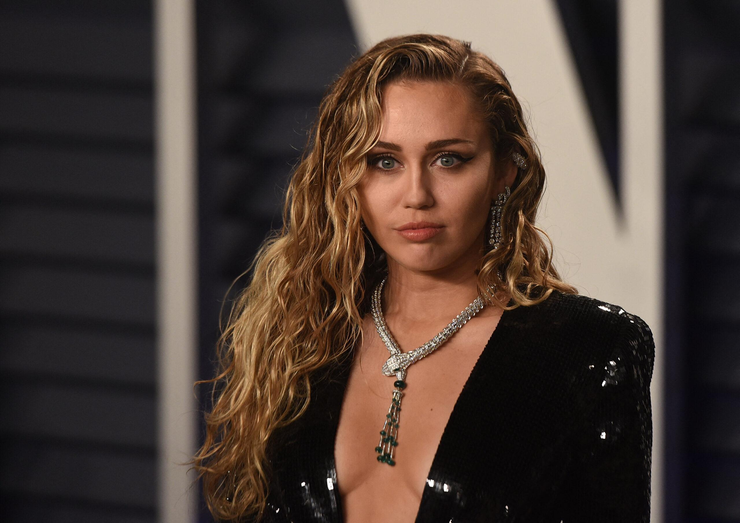 Miley Cyrus poses on the red carpet of Vanity Fair Oscar Party