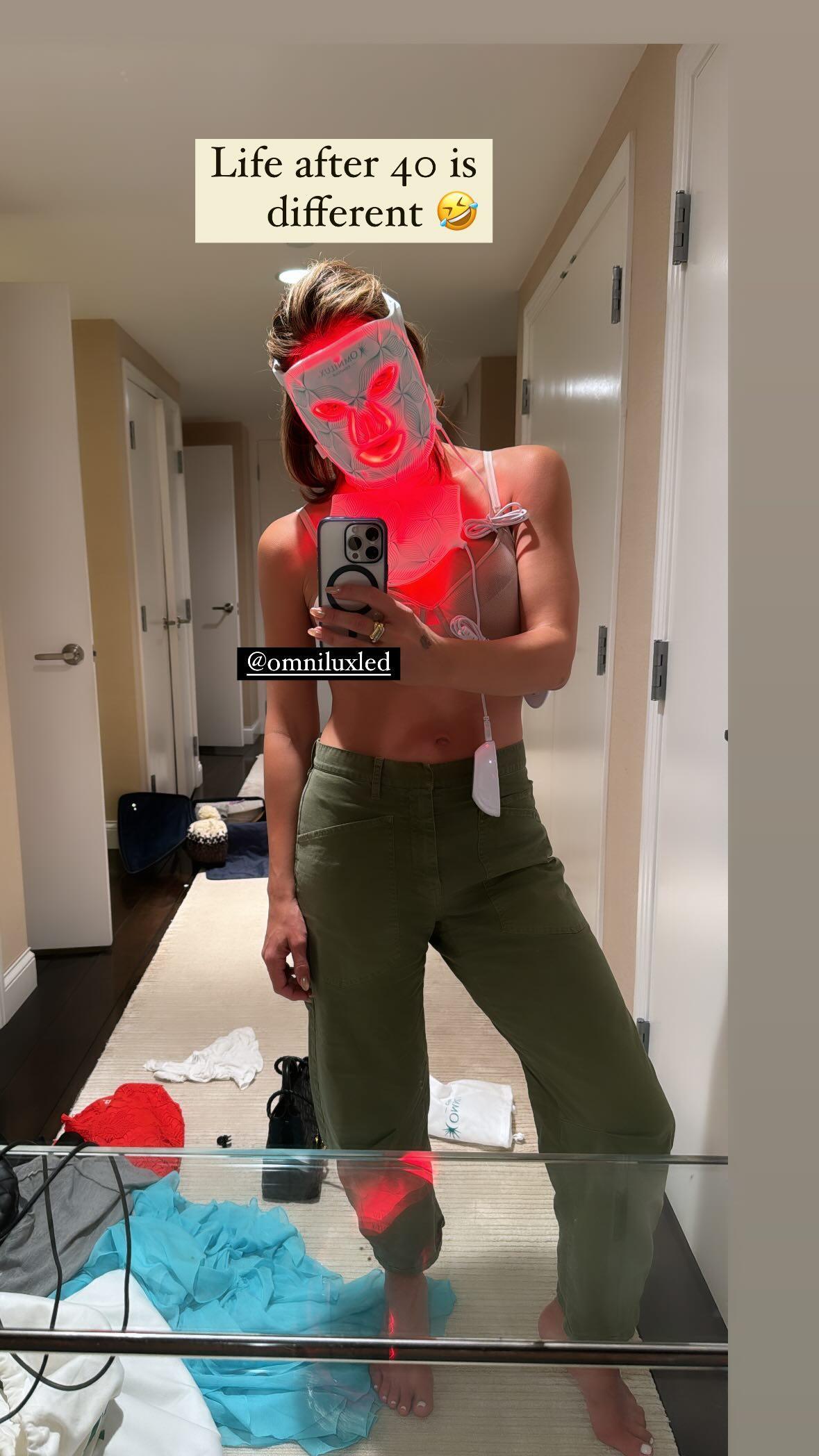Katharine McPhee snaps a selfie while wearing an LED face mask.