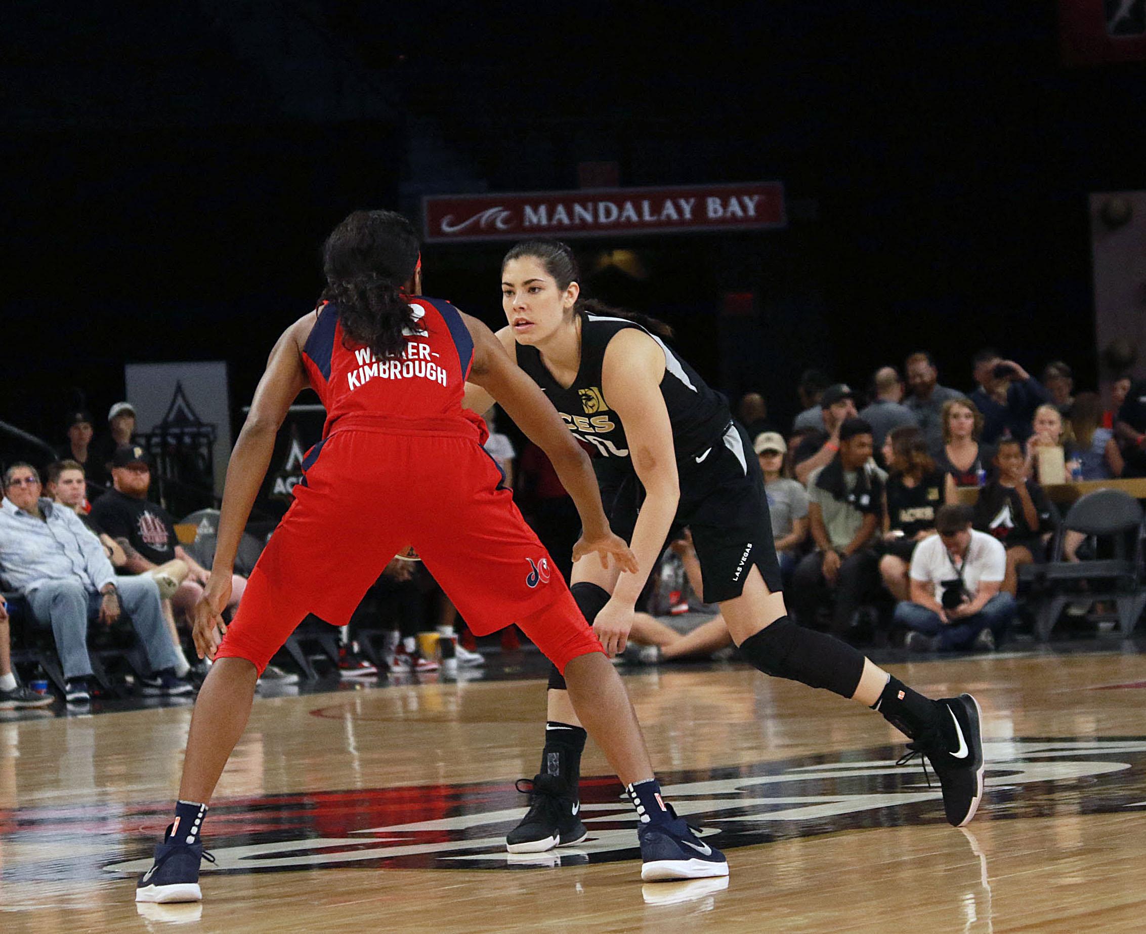 Two women play basketball.