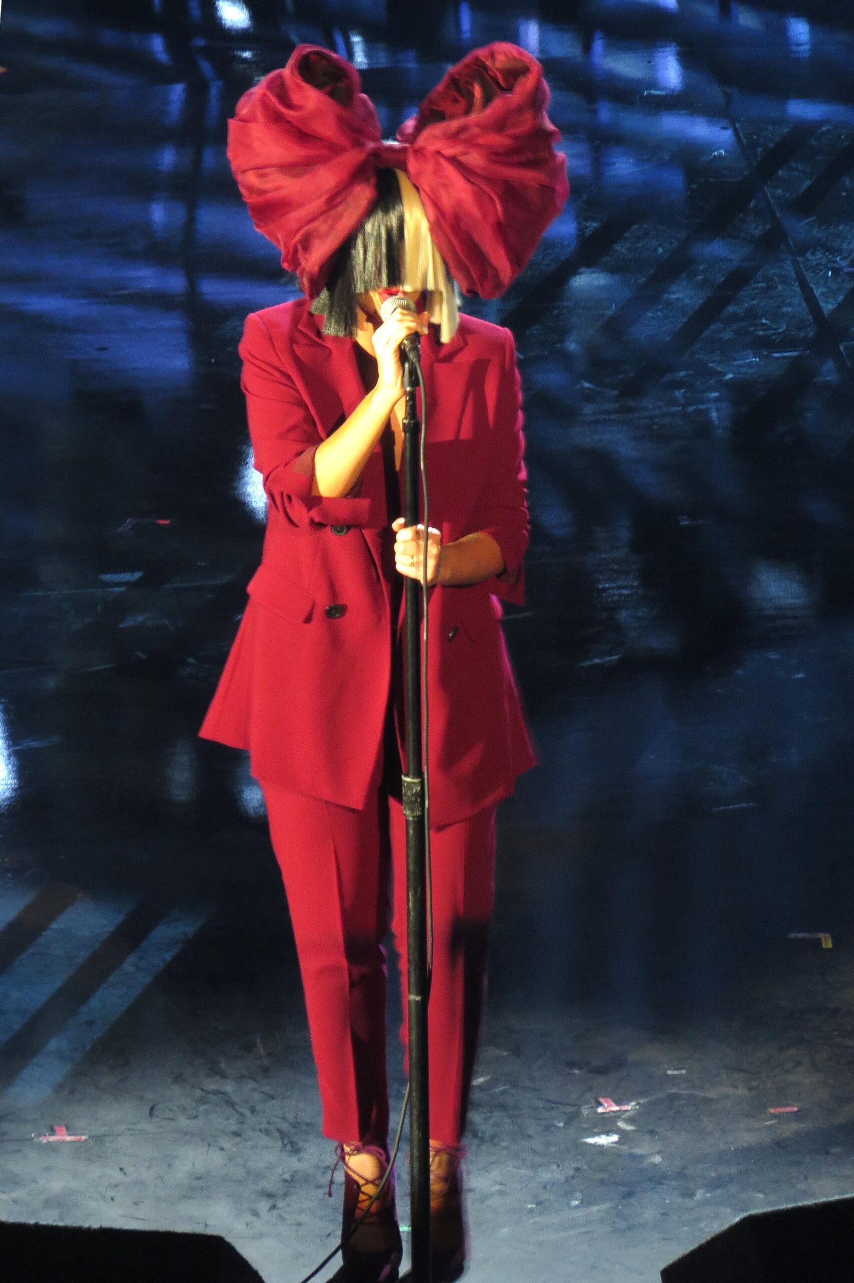 Sia se apresenta no palco.