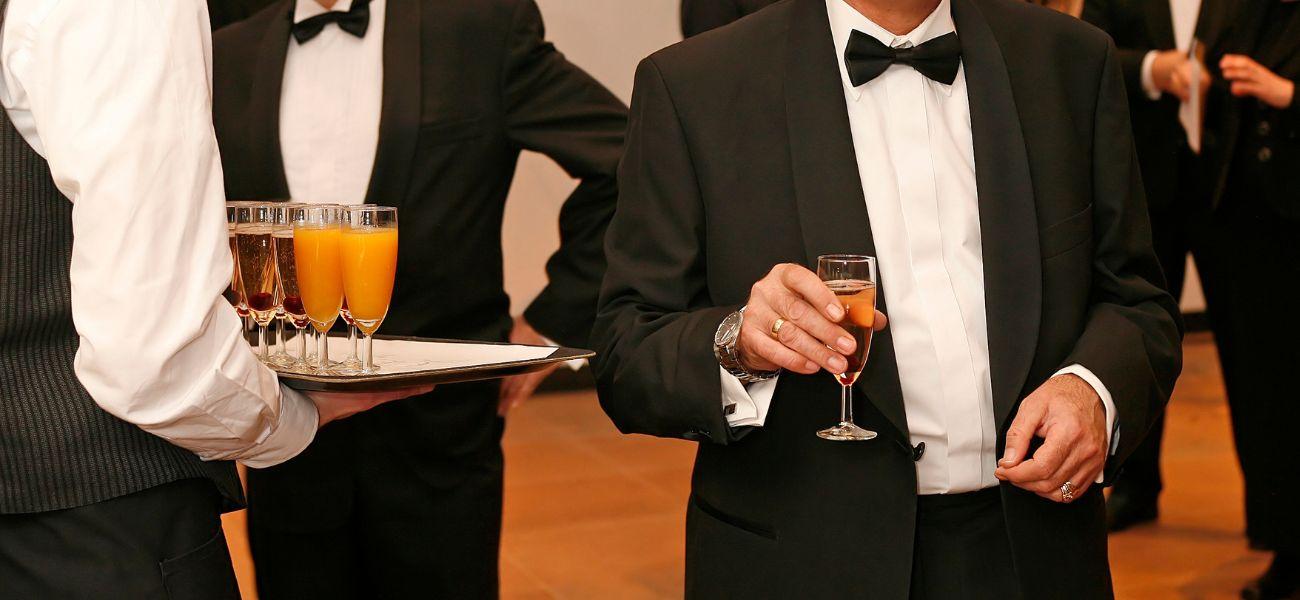 Man in a tux holding a glass of champagne