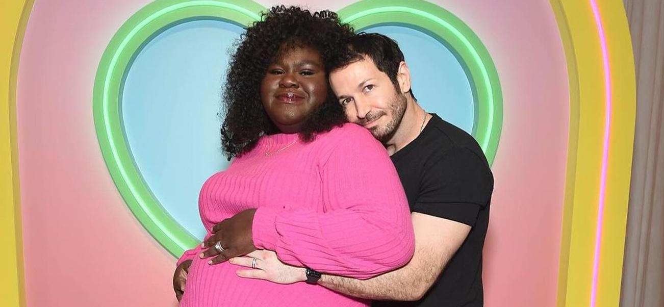 Gabby Sidibe's husband Brandon Frankel embraces her from behind.