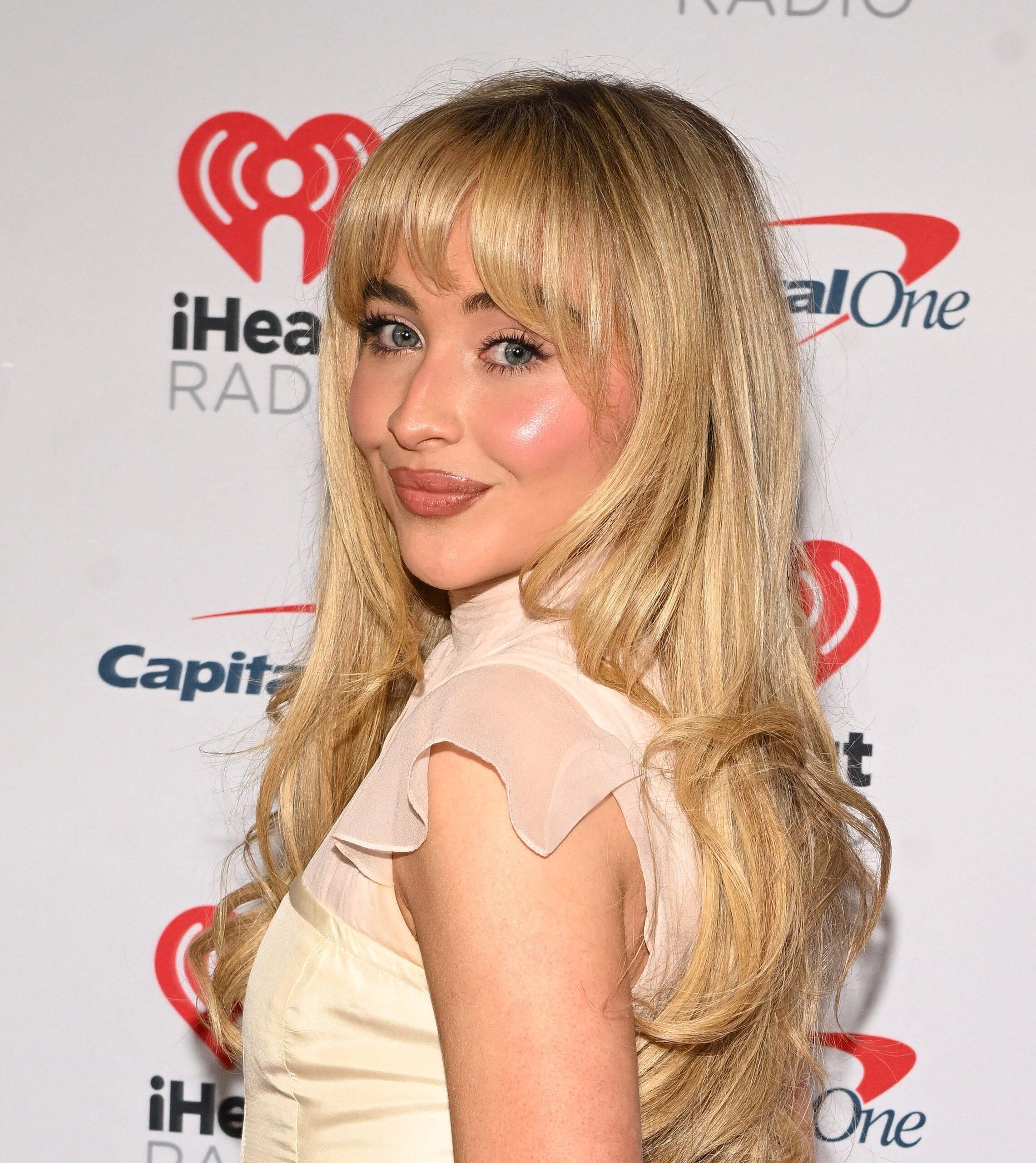 Sabrina Carpenter smiling in white dress