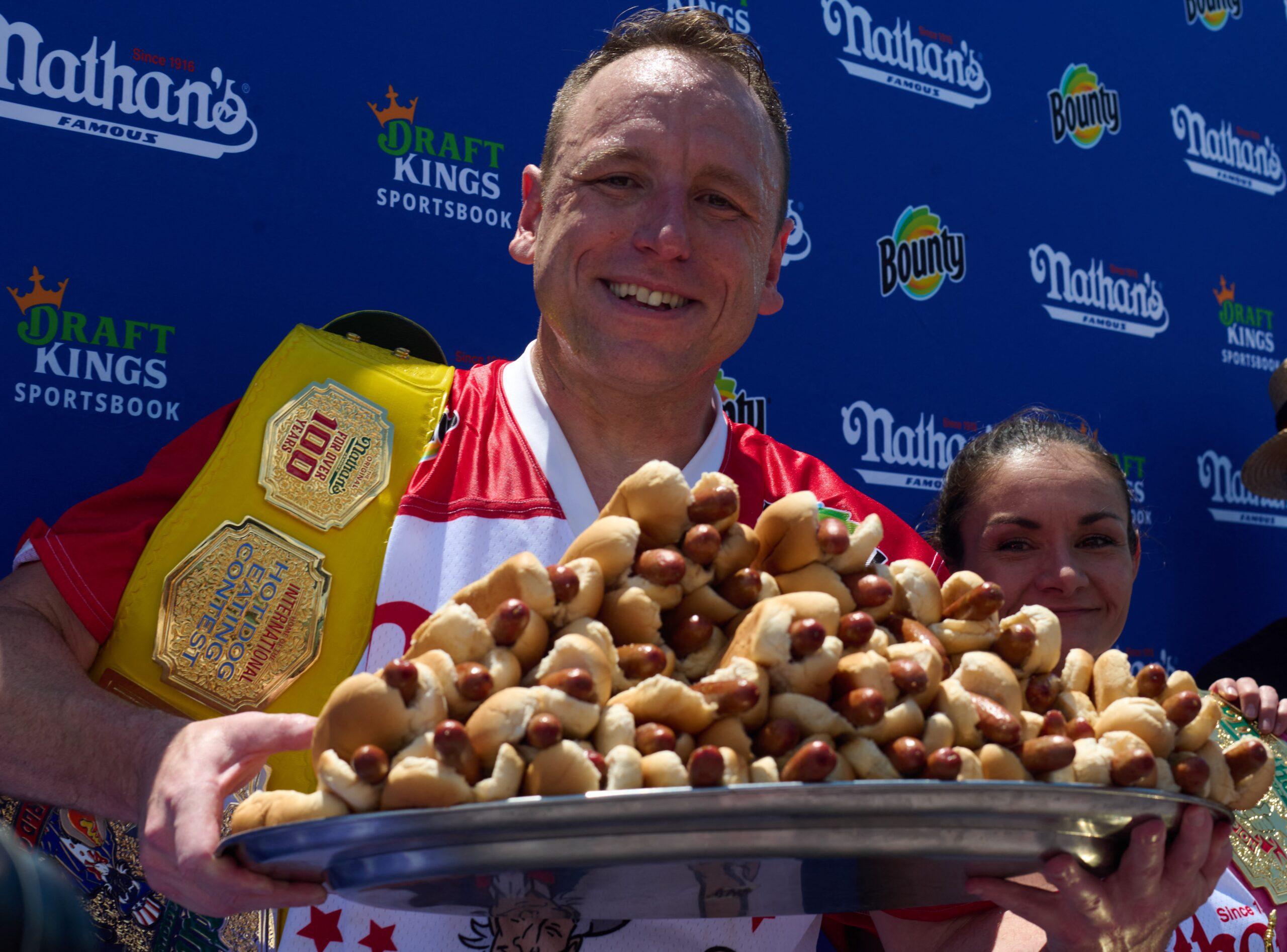 Joey Chestnut holding a plate of hot dogs