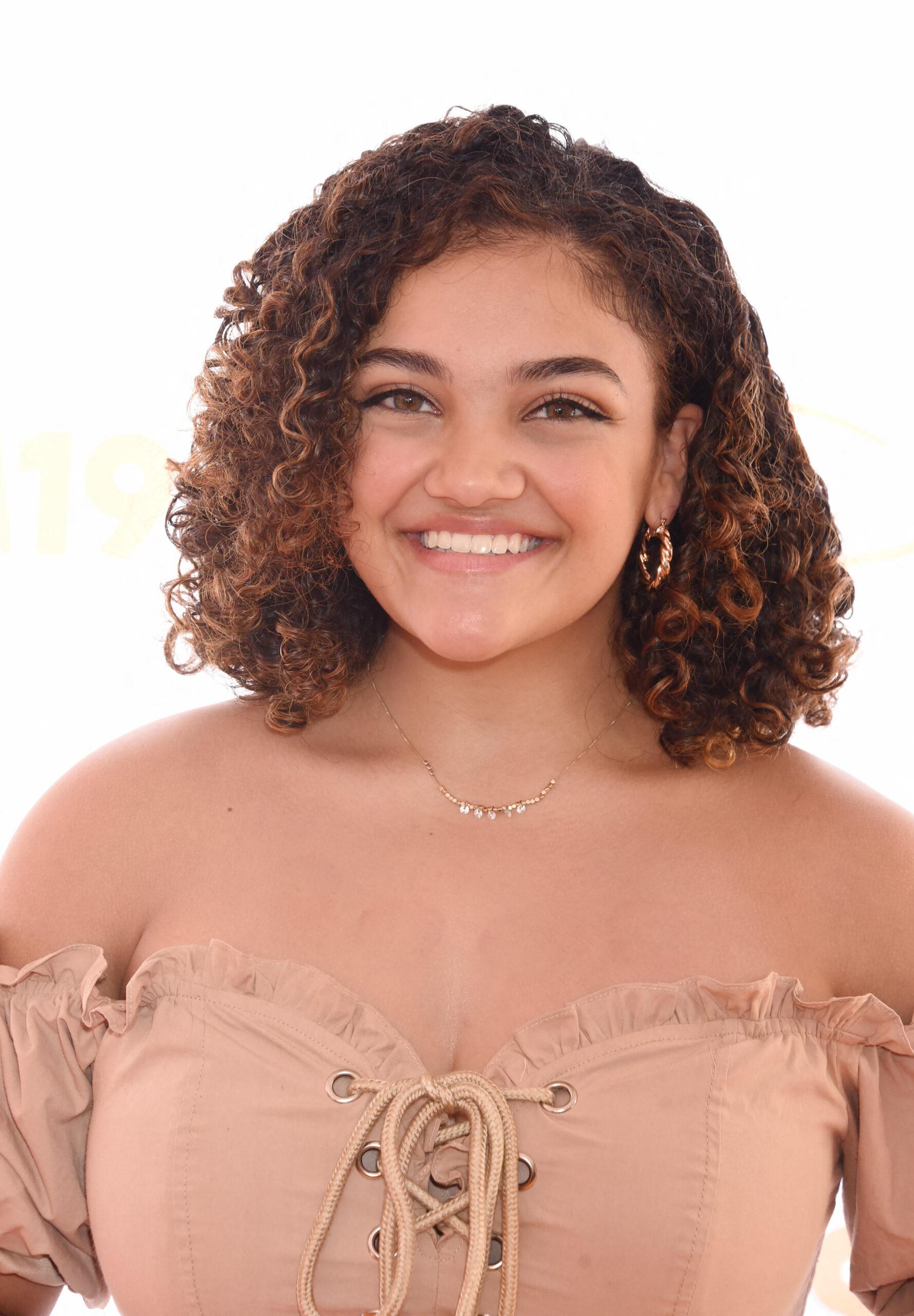 Laurie Hernandez em vestido rosa claro