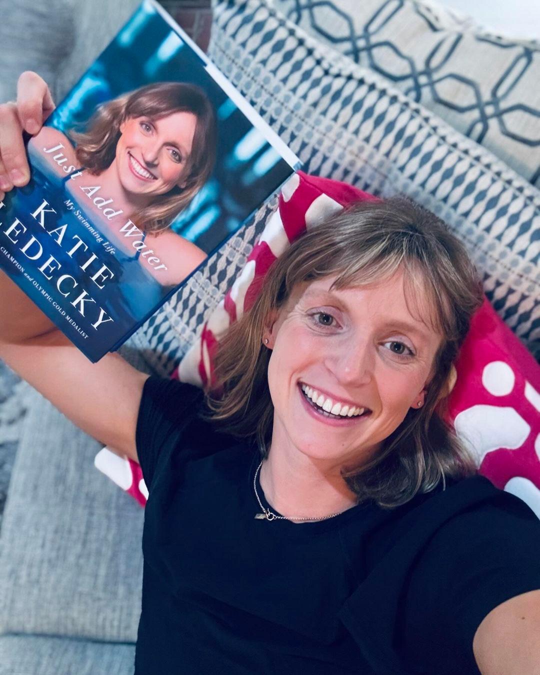 Katie Ledecky segurando seu novo livro de memórias