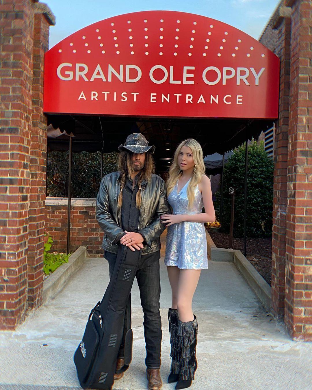 Firerose e Billy Ray Cyrus posam juntos do lado de fora do Grand Ole Opry