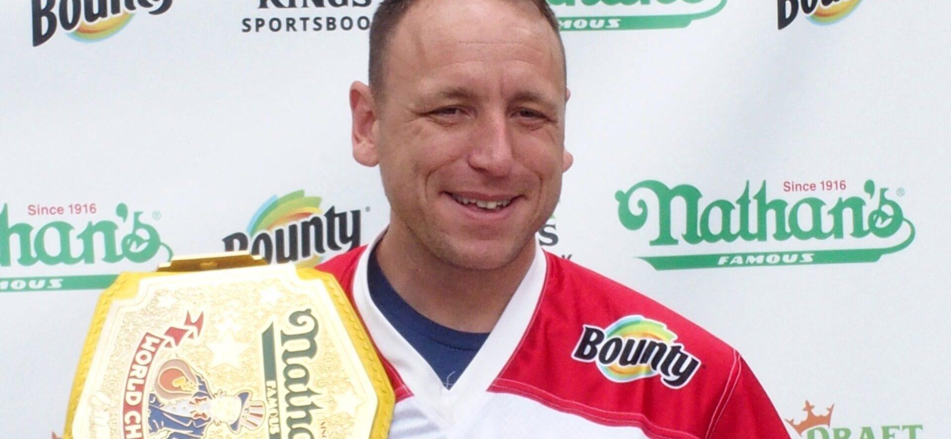 Joey Chestnut holding a plate of hot dogs at Nathan's July 4th Hot Dog Eating Contest 2021