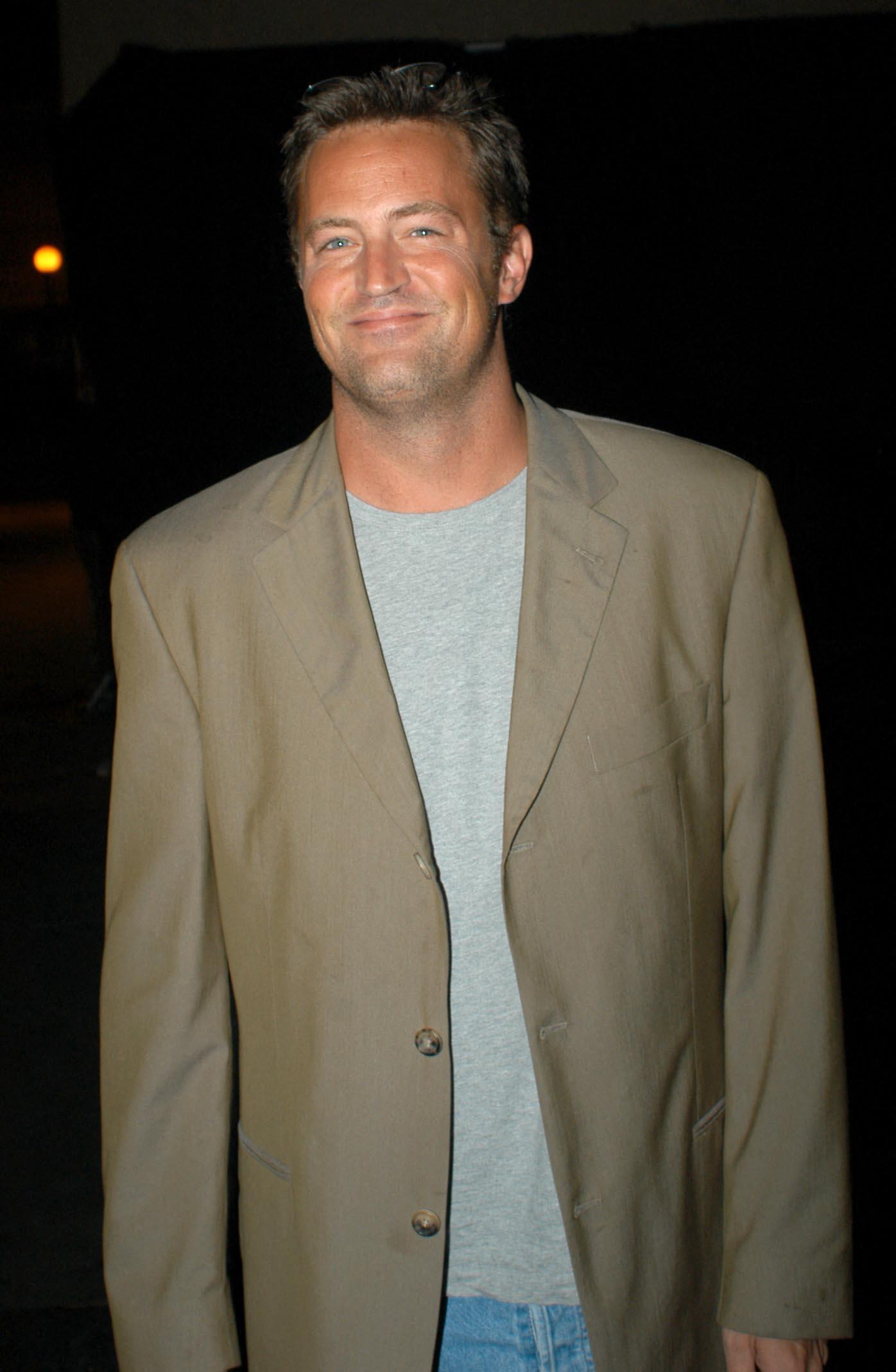 Matthew Perry in a beige suit jacket