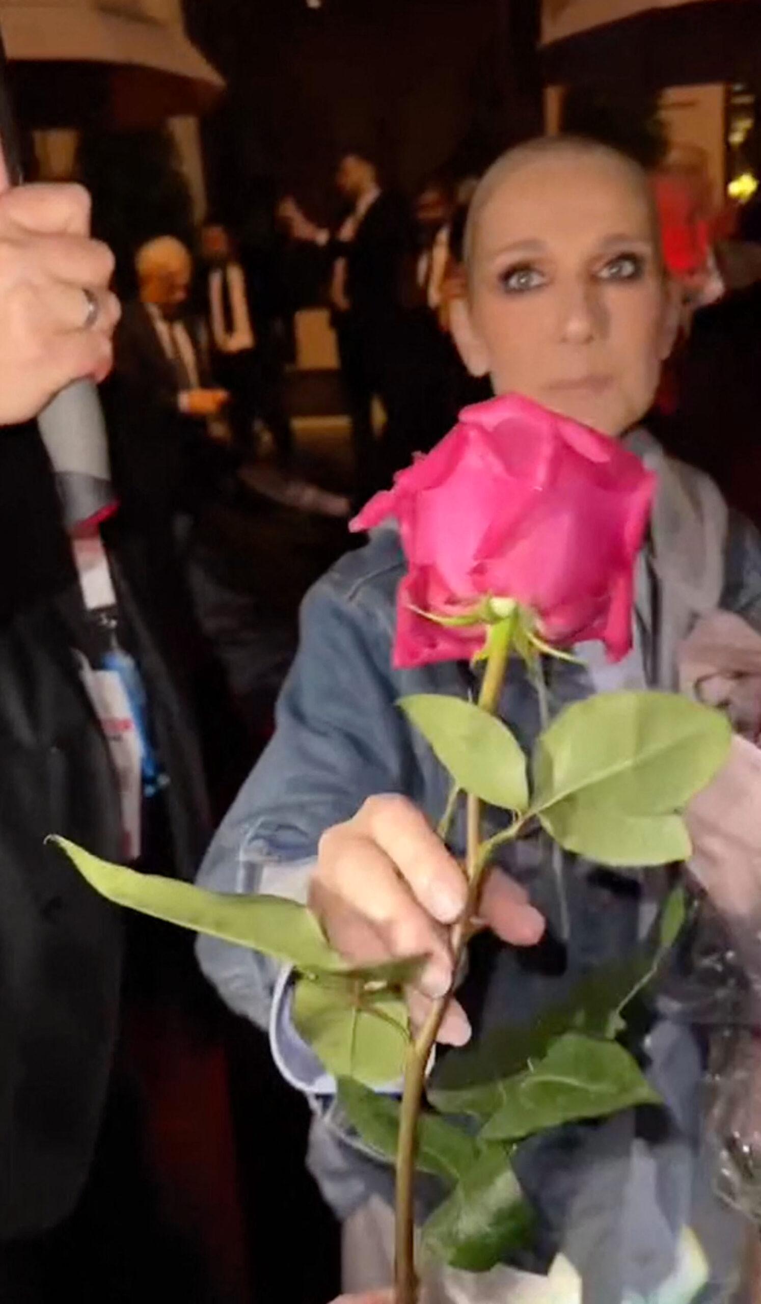 Celine Dion looks emotional as she receives a rose from a fan after performing at the Olympics opening ceremony