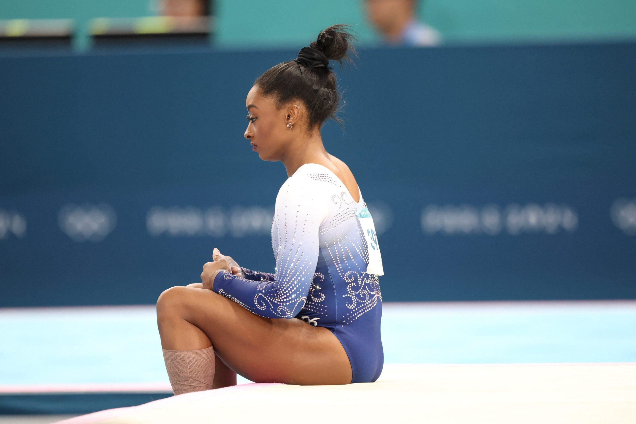 Simone Biles sitting on the floor at the 2024 Olympics