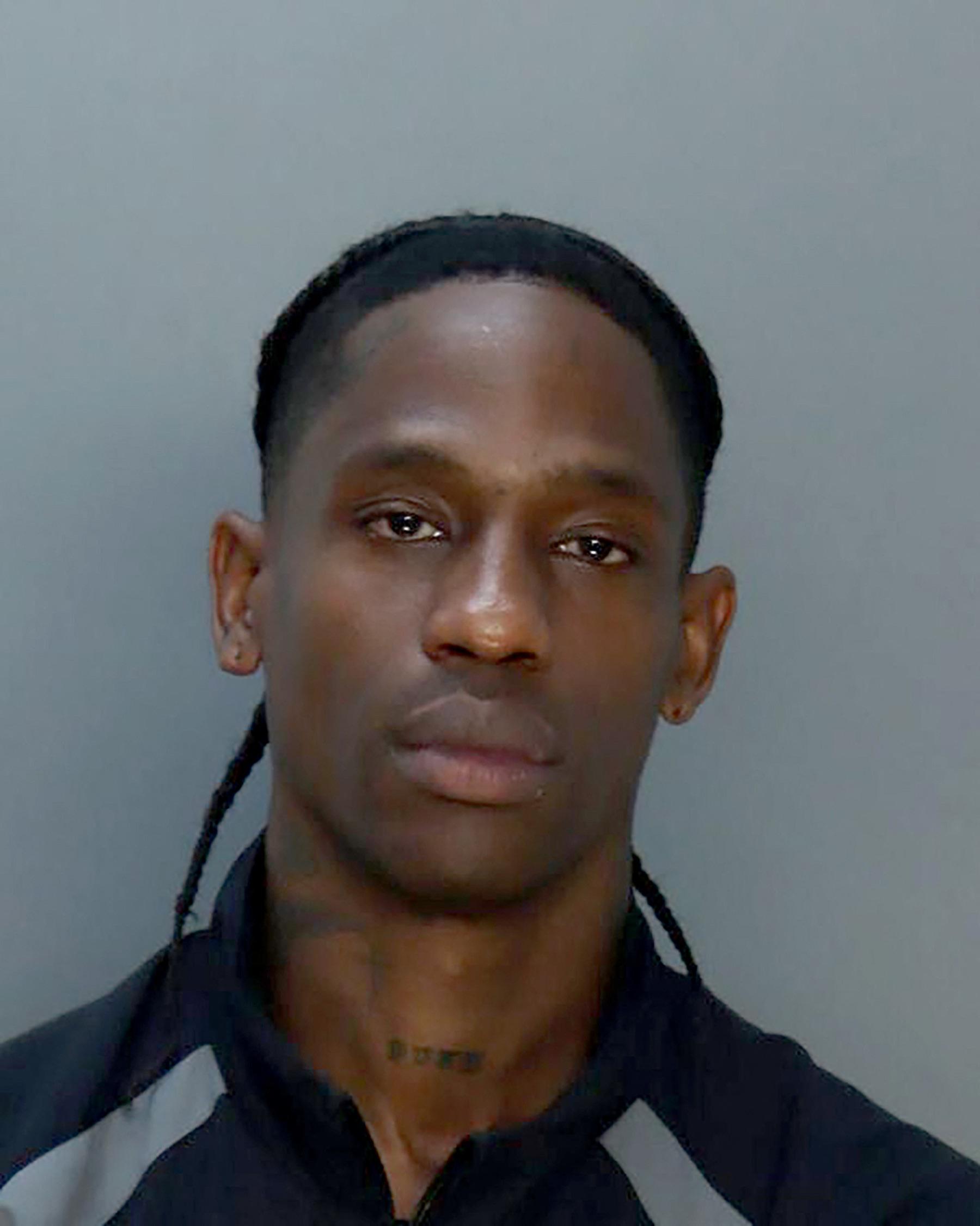 Travis Scott's bleary-eyed mugshot after arrest for disorderly intoxication and trespassing in Miami.