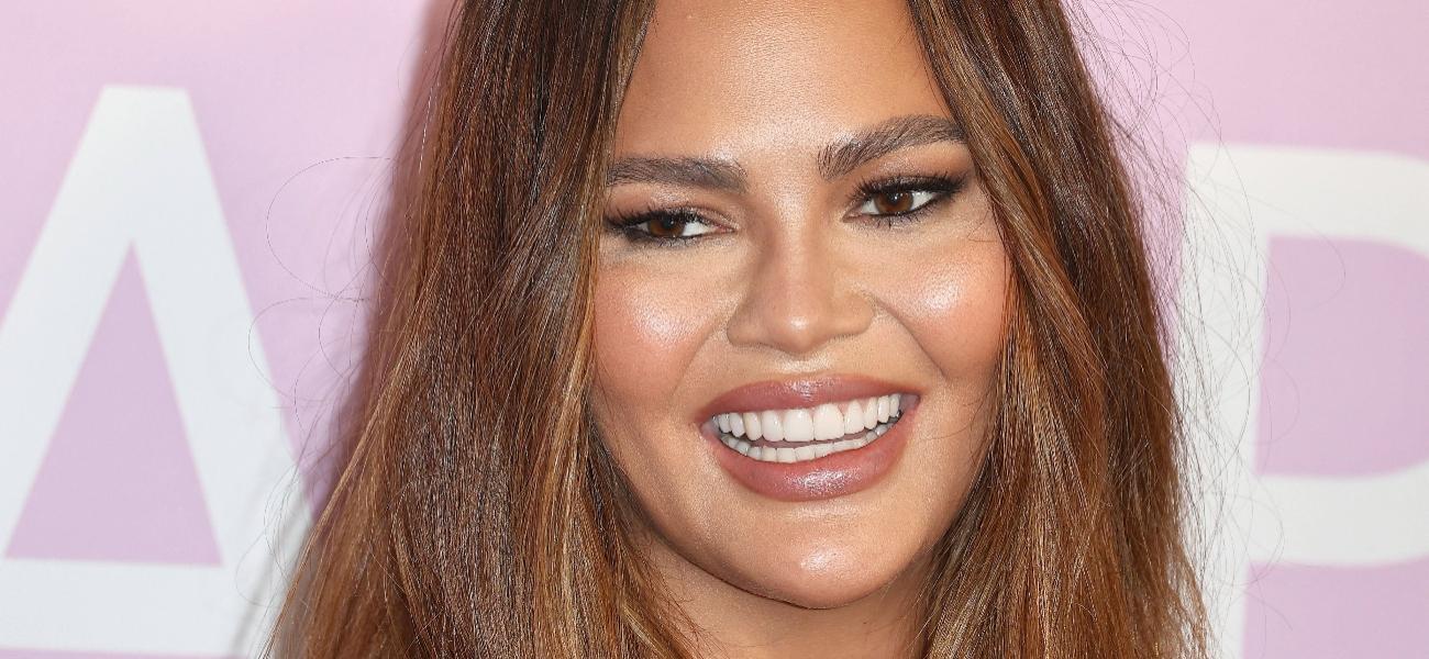 Chrissy Teigen smiles at an event