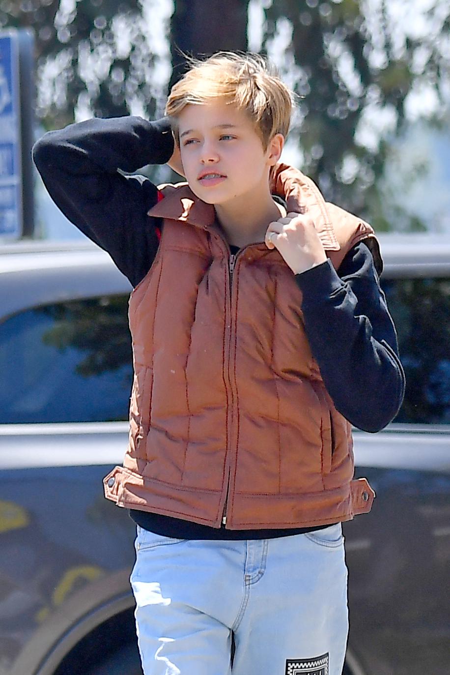 Shiloh Jolie-Pitt usa shorts Versace em viagem à Best Buy