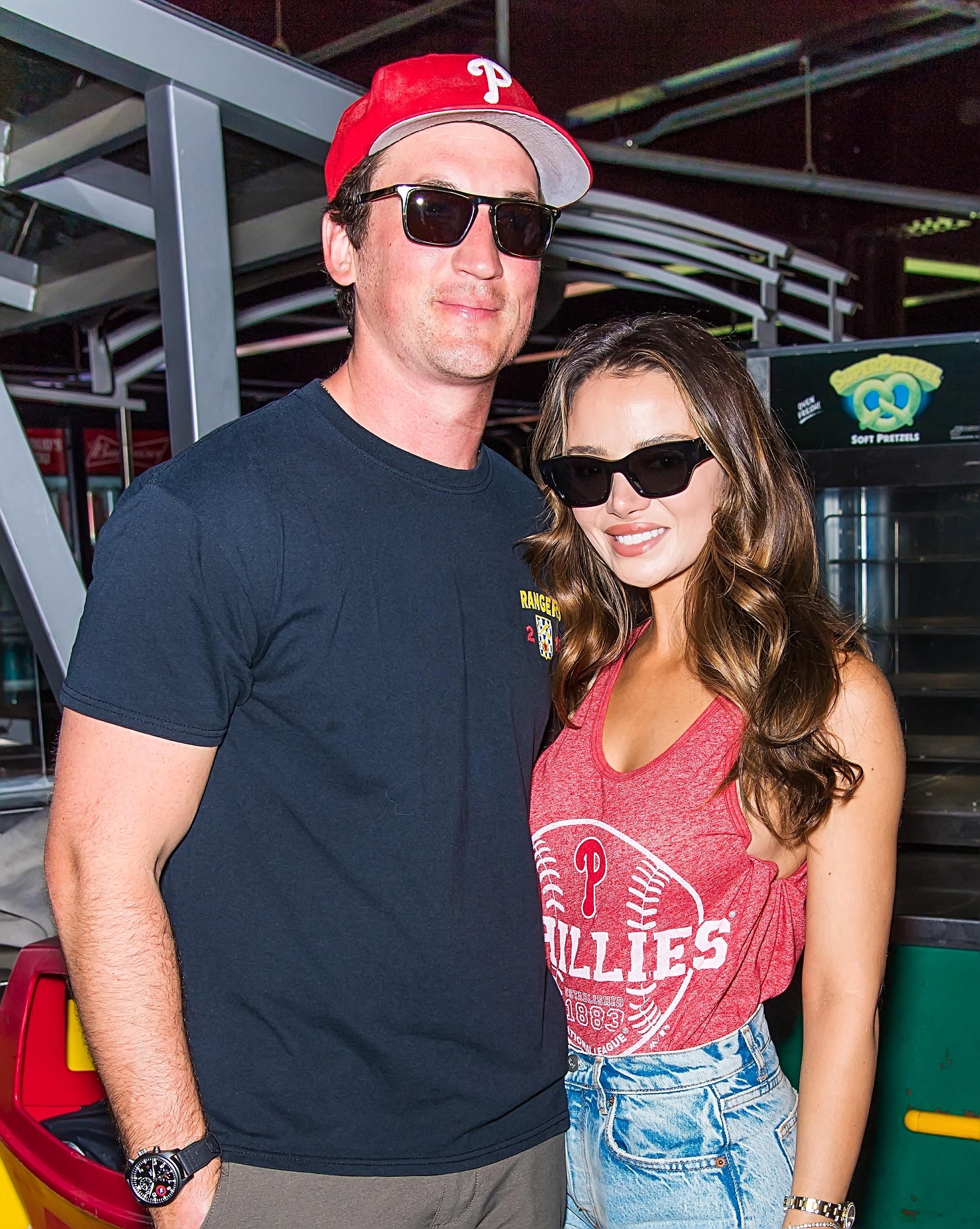 Miles Teller e Keleigh Sperry posando usando óculos escuros