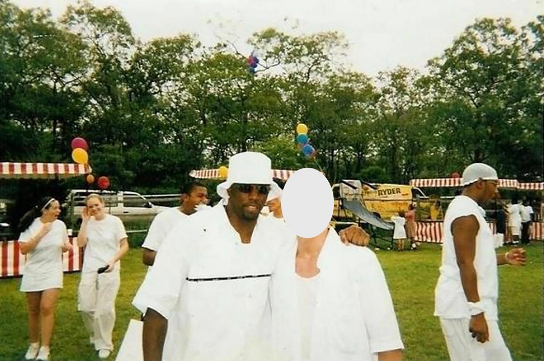 Sean 'Diddy' Combs é visto passando o braço em volta de um garoto de 16 anos que ele supostamente abusou sexualmente em uma festa branca nos Hamptons em 1998.