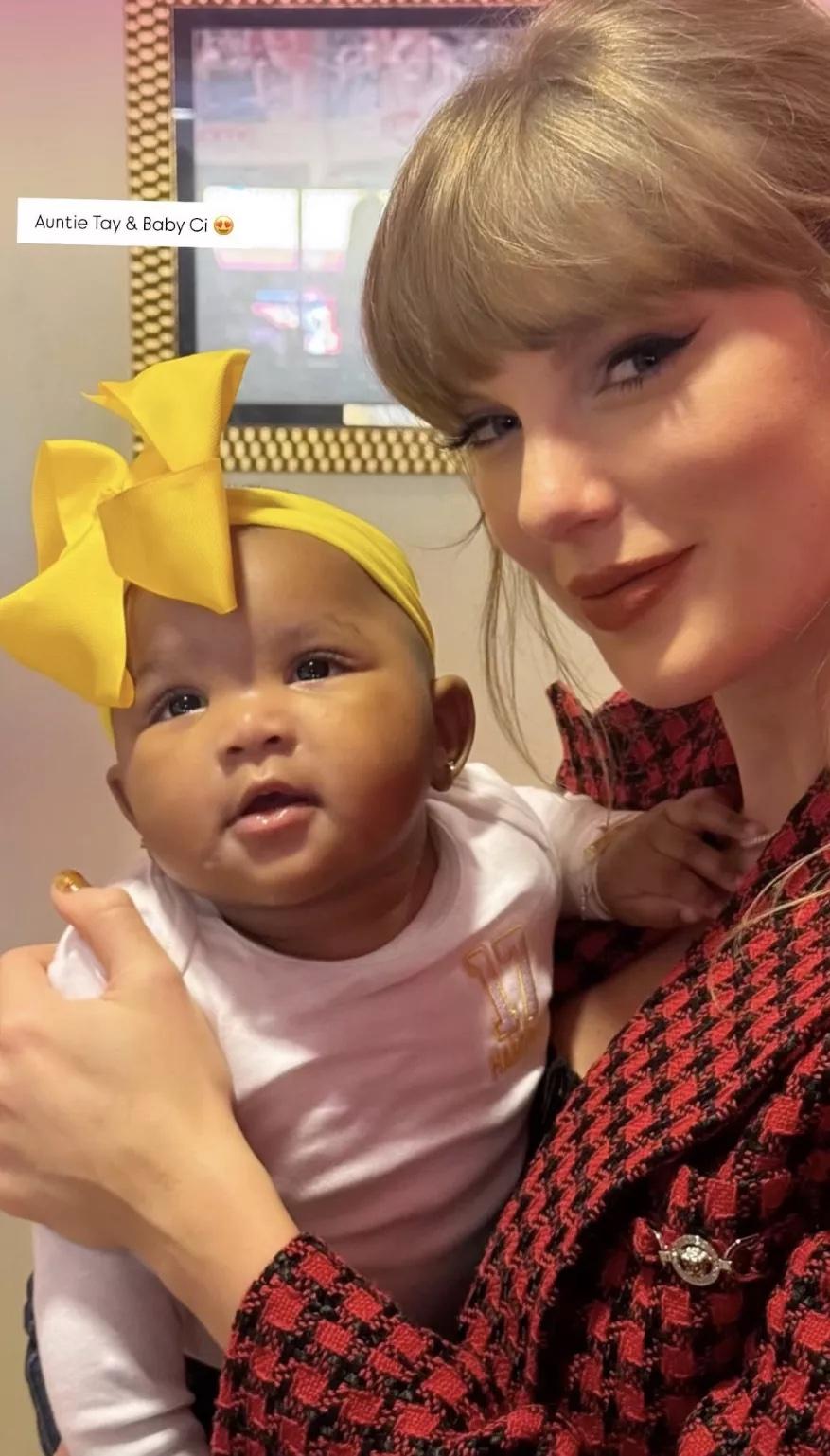 Taylor Swift sosteniendo la hija de Asia Gordon