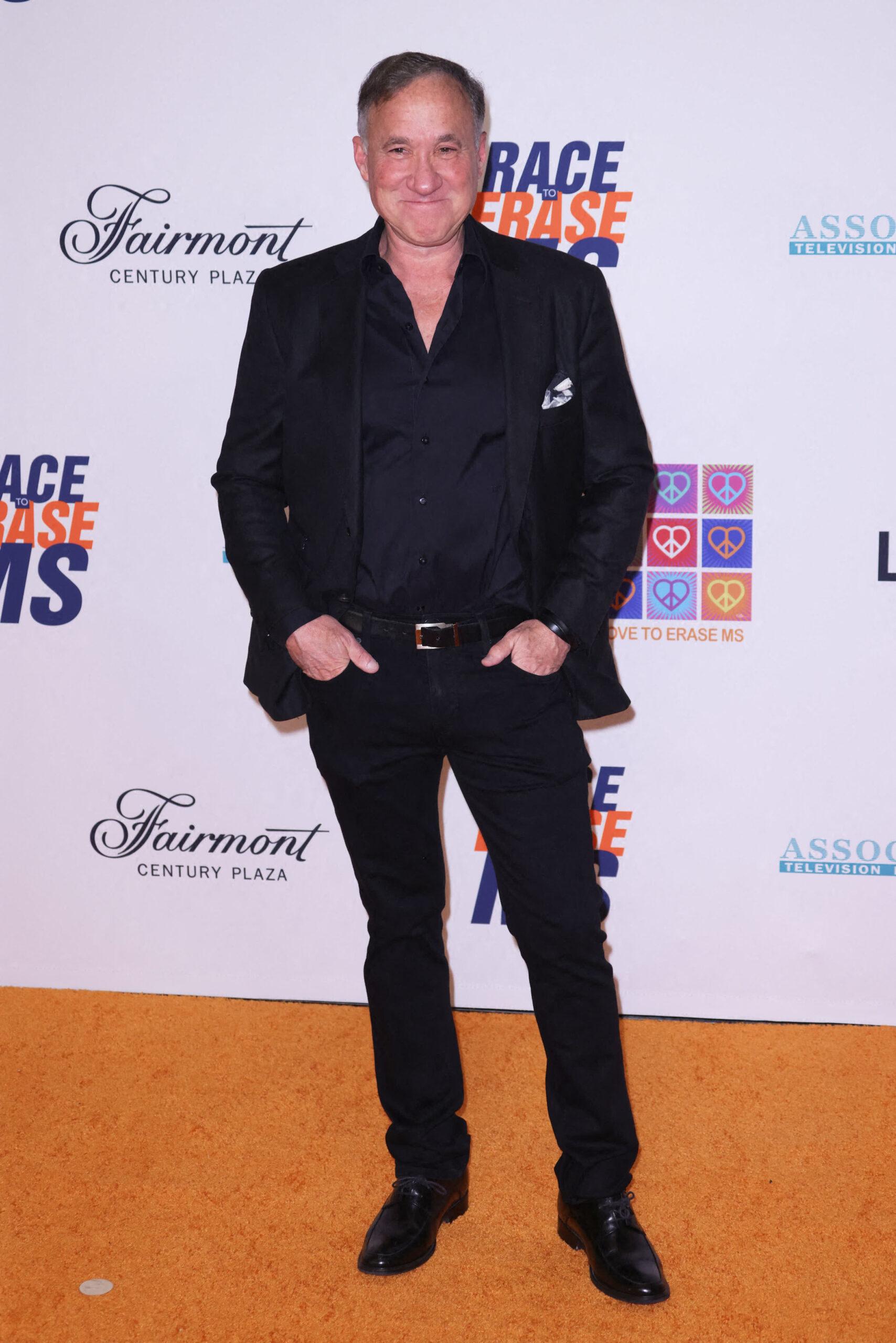 Photo shows Dr. Terry Dubrow wearing a black suit and pants on the red carpet