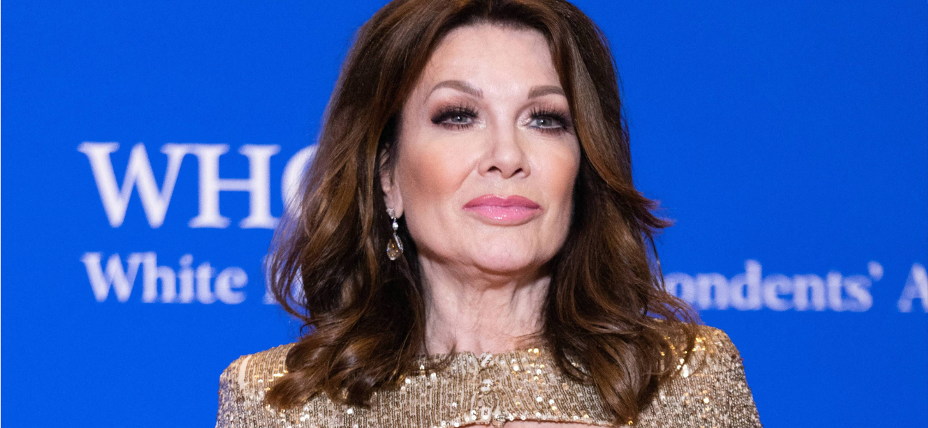 Lisa Vanderpump posing in a gold dress on the red carpet.