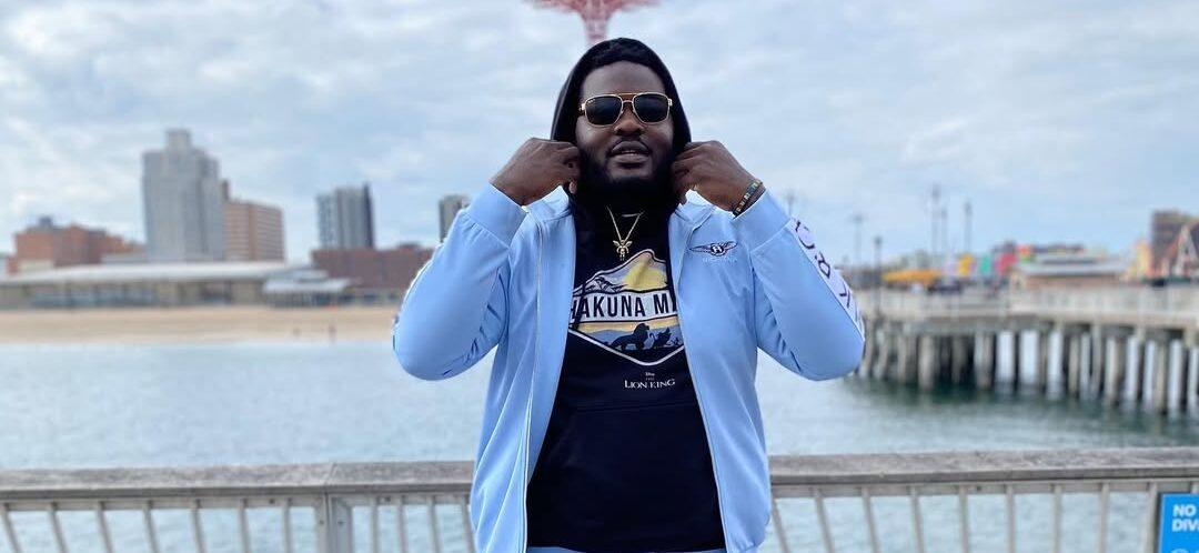 Ronald Ollie in a blue tracksuit in front of a beach.