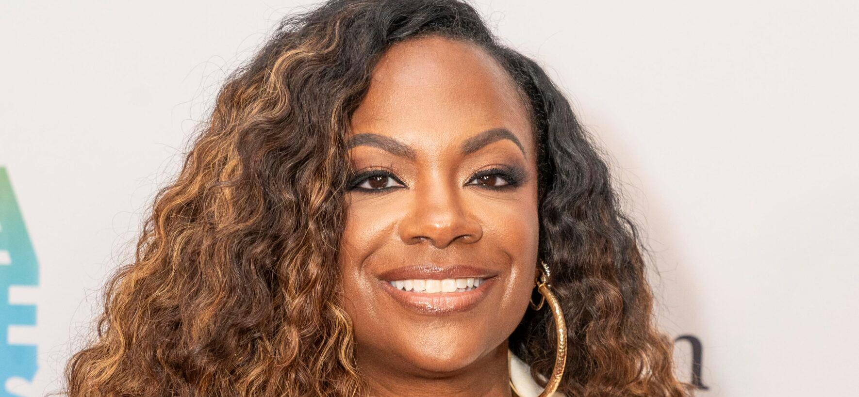 Kandi Burruss smiling while posing on the red carpet.