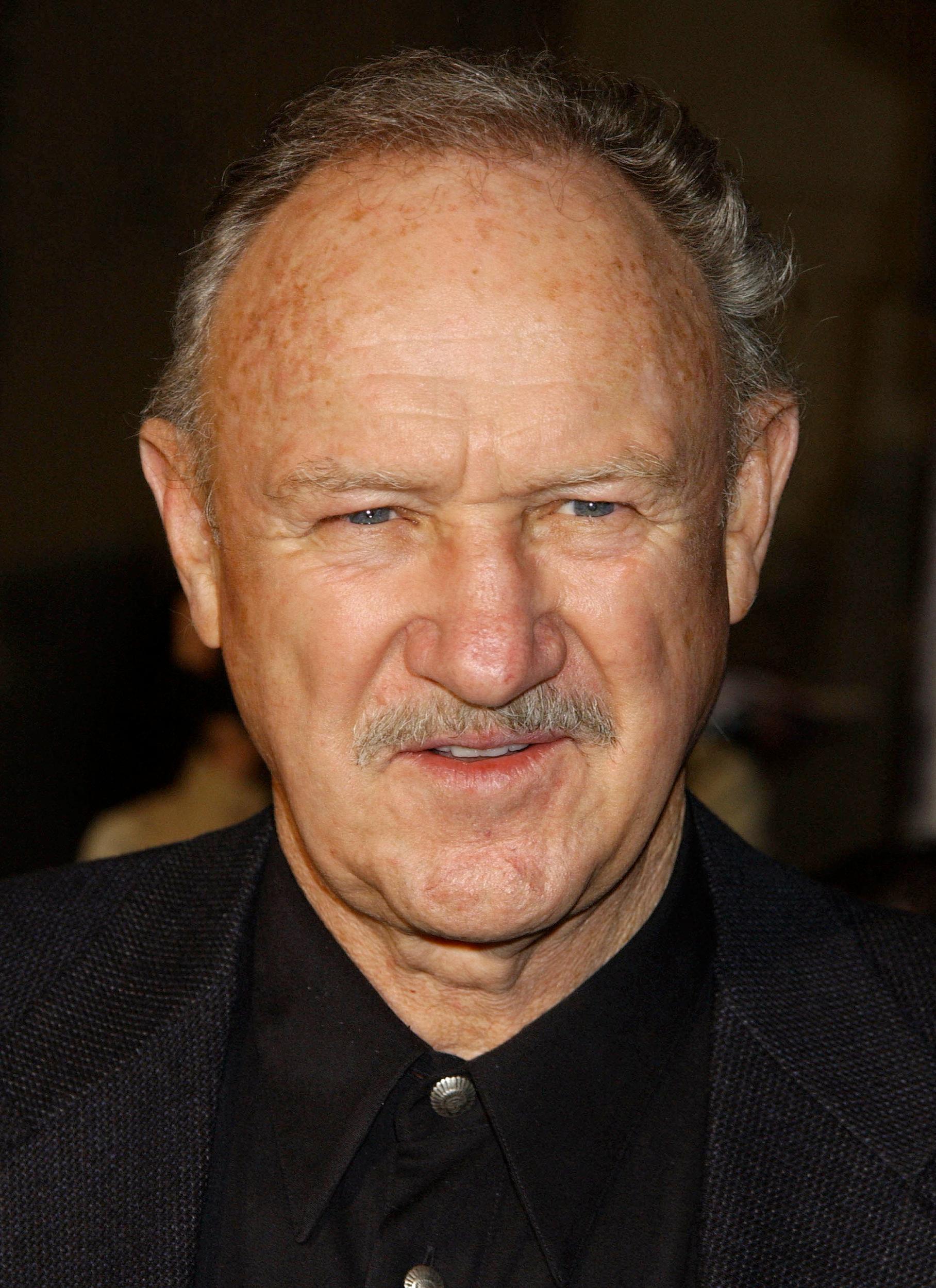 Gene Hackman mengenakan warna hitam